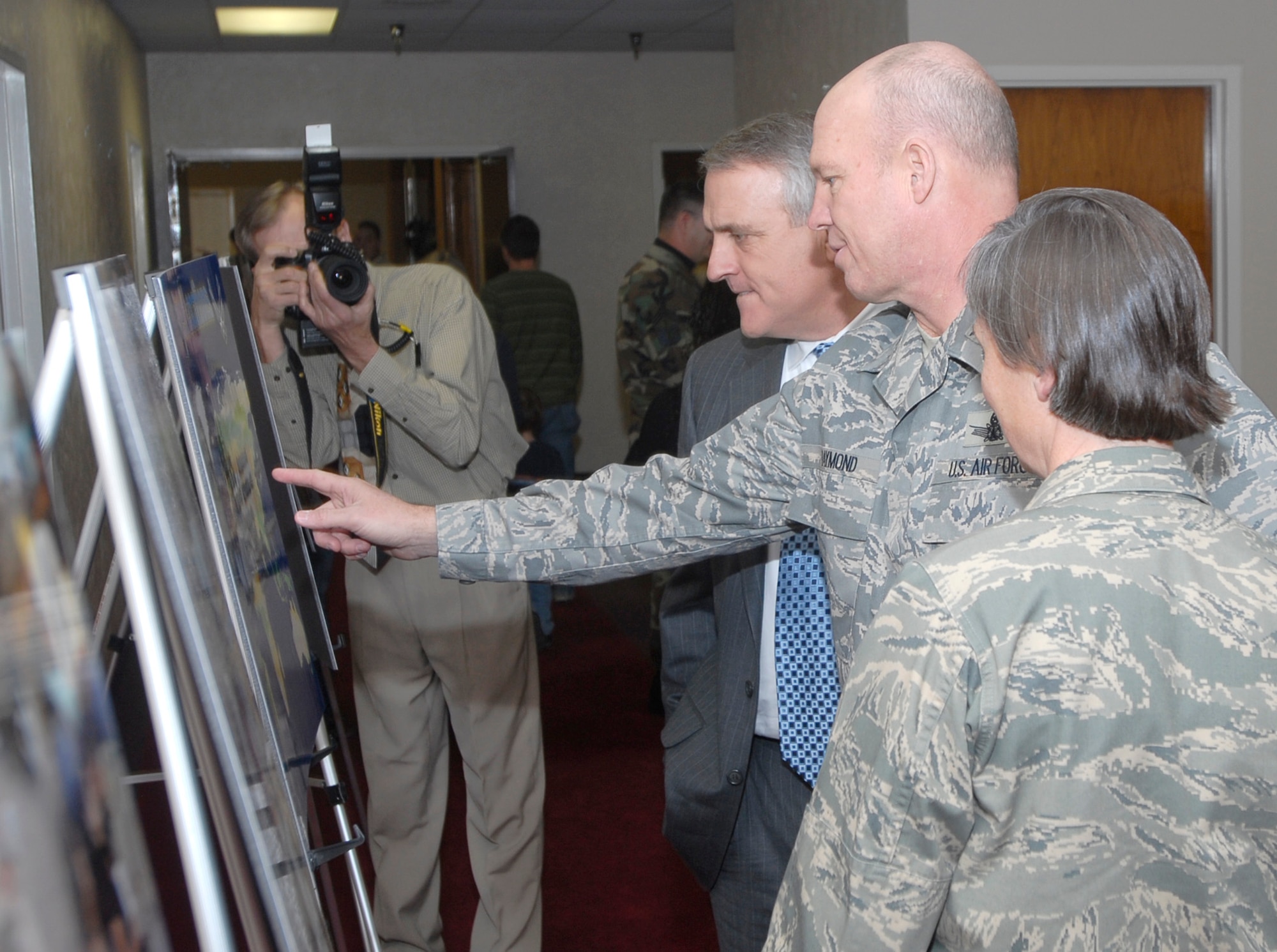 Col. Jay Raymond, 21st Space Wing commander (center), explains to Colorado Gov. Bill Ritter, Jr., how both Peterson and Schriever AFB support families of deployed Airmen during the monthly Deployed Families Dinner Jan. 4. During the event, Governor Ritter met more than 200 family members, and expressed his support for them and their deployed spouses. Col. Teresa Djuric, 50th Space Wing commander (right), is also present. (U.S. Air Force photo/Rob Lingley) 
