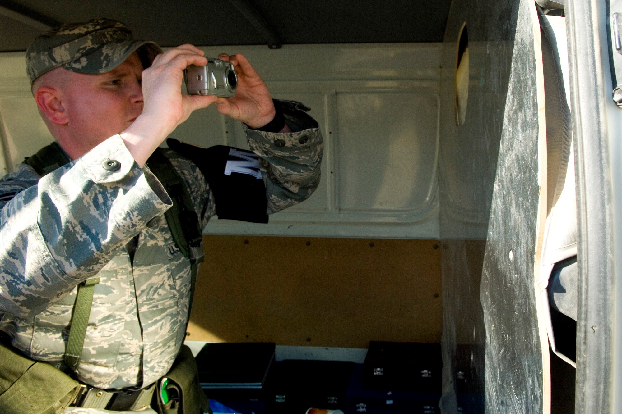Staff Sgt. Jeremy West takes a photograph of evidence after responding to a property damage call Dec. 27 at Balad Air Base, Iraq. The photos will become part of the official report documenting the incident. Sergeant West is a 332nd Expeditionary Security Forces Squadron Det. 1 Provost Marshal Office patrolman and deployed from McConnell Air Force Base, Kan. (U.S. Air Force photo/Staff Sgt. Travis Edwards) 
