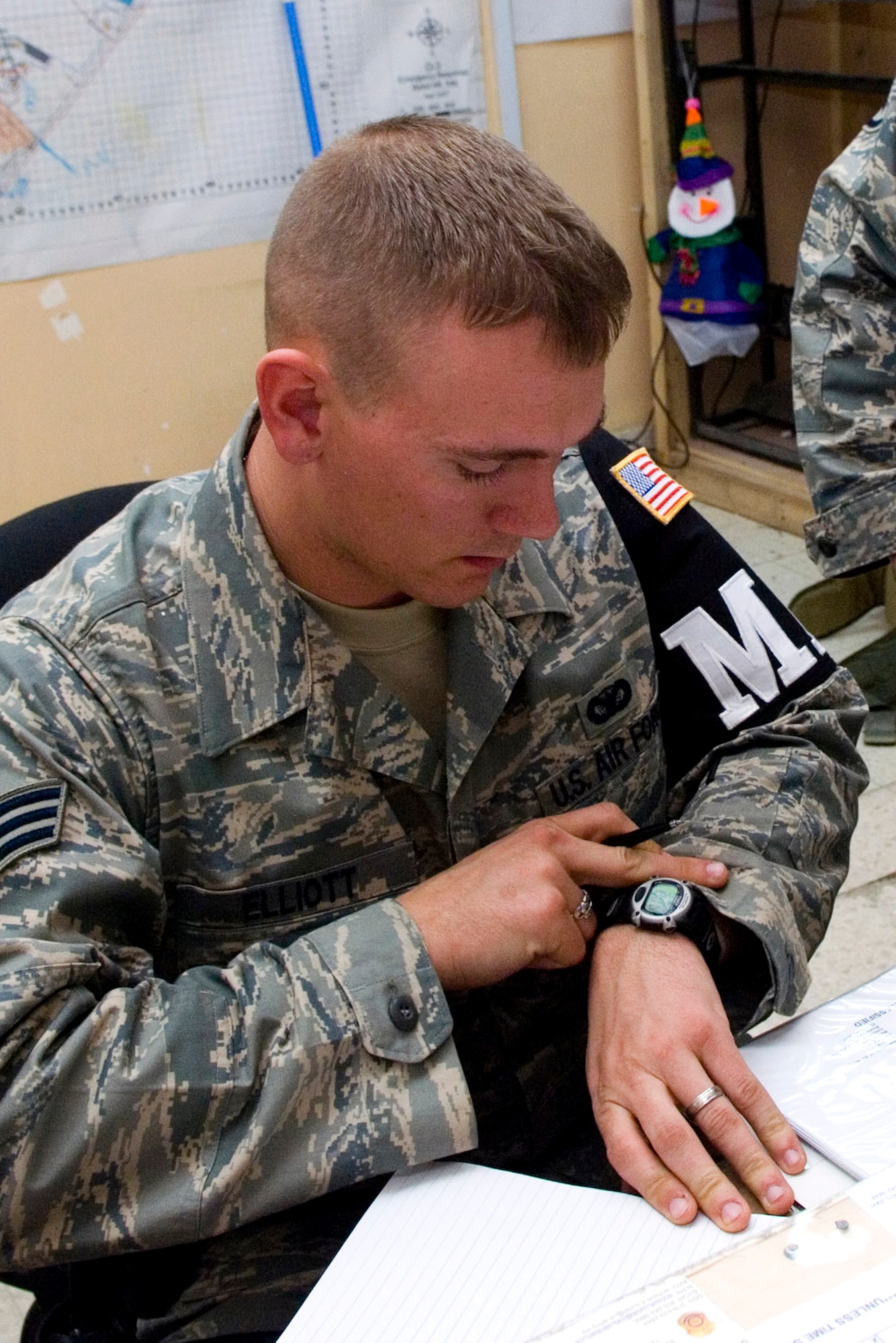 Senior Airman Jon Elliott checks his watch to jot down the time a patrolmen responded to a medical emergency Dec. 26 at Balad Air Base, Iraq. Airman Elliott is a 332nd Expeditionary Security Forces Squadron Detachment 1 Provost Marshal Office desk clerk and deployed from Whiteman Air Force Base, Mo. (U.S. Air Force photo/Staff Sgt. Travis Edwards) 
