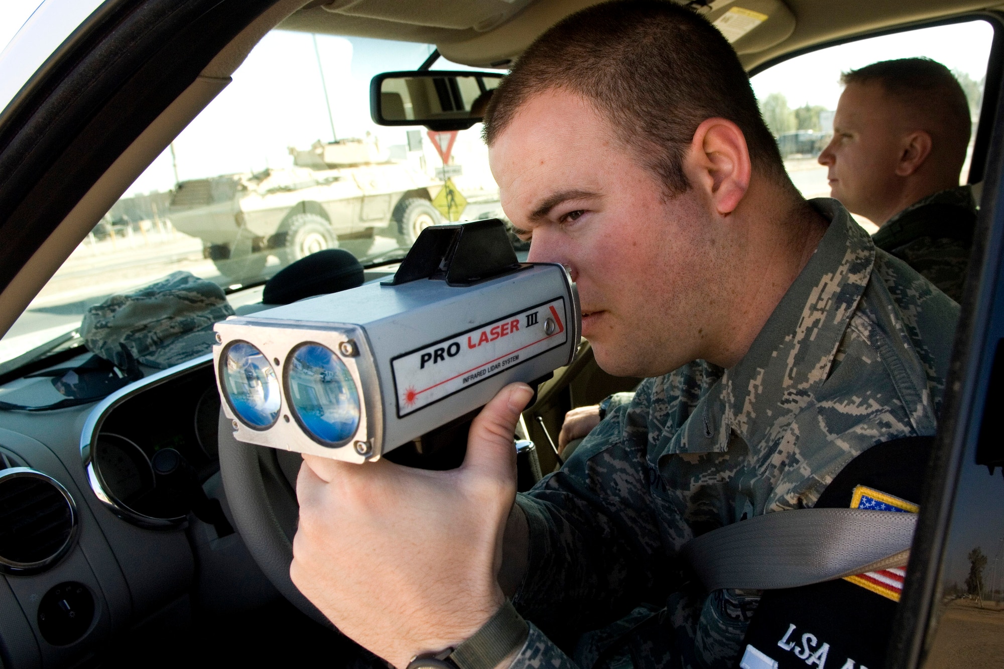 Airman 1st Class Brandon Sutton uses his infrared LIDAR speed detector to determine the speed of passing vehicles Dec. 27 at Balad Air Base, Iraq. Airman Sutton is a 332nd Expeditionary Security Forces Squadron Det. 1 Provost Marshal Office patrolman and deployed from McConnell Air Force Base, Kan. (U.S. Air Force photo/Staff Sgt. Travis Edwards) 
