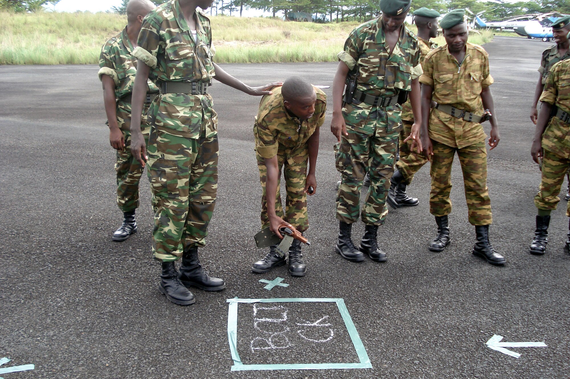 A Burundi soldier learns how to set up a weapons check for fellow soldiers boarding a Ugandan C-130 en route to Somalia Dec. 13 in Burundi. Airmen of the 86th Contingency Response Group from Ramstein Air Base, Germany, trained the Burundi force throughout December. (Courtesy photo) 
            
