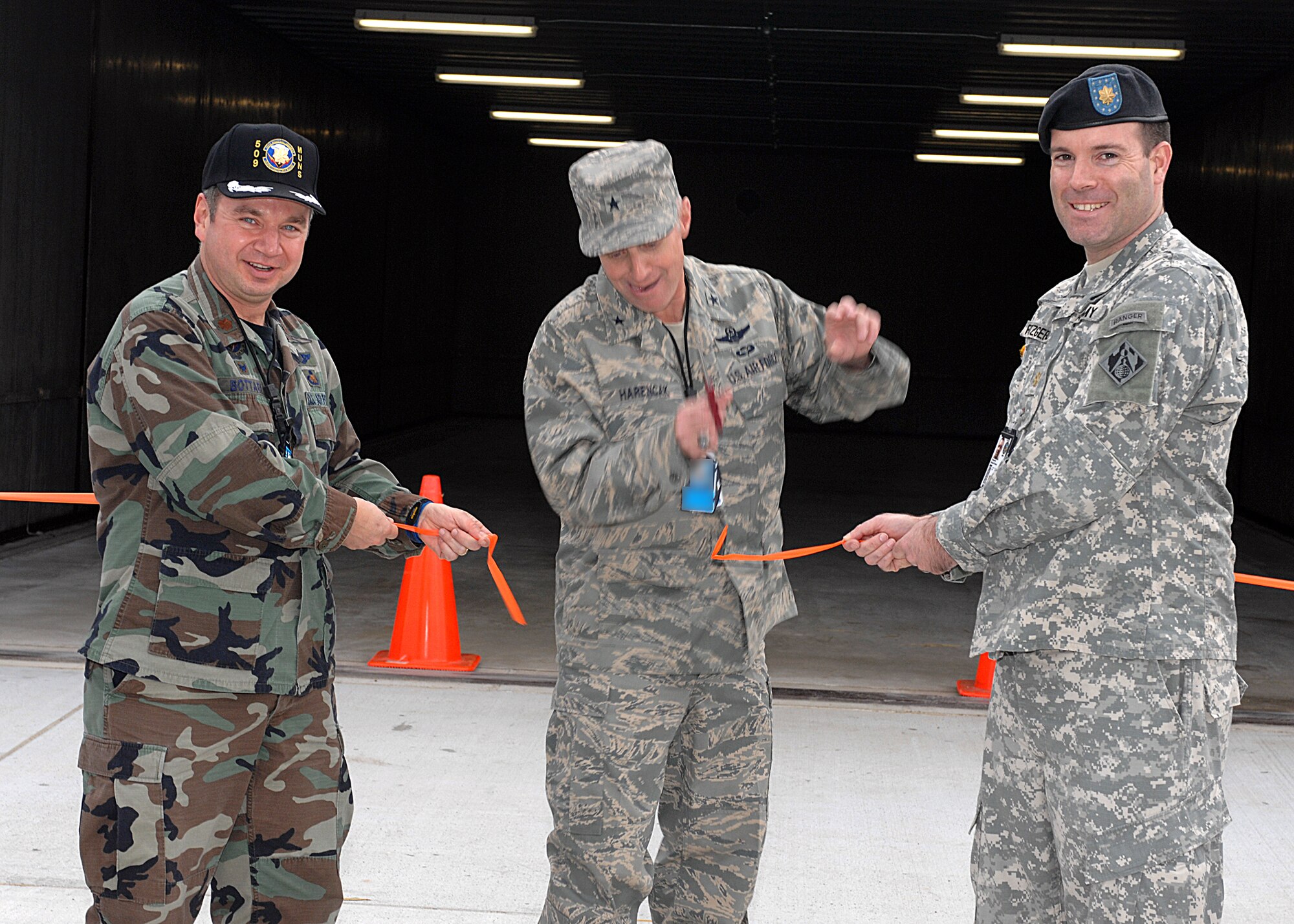 WHITEMAN AIR FORCE BASE, Mo. – Maj. Kenneth Bottari, 509th Munitions Squadron commander, Brig. Gen. Garrett Harencak, 509th Bomb Wing commander and Major Michael Fitzgerald, U.S. Army Corps of Engineers, cuts the ribbon for the grand opening of the new Igloos in the Weapon Storage Area Jan. 7. The munitions igloo project broke ground in May 2006 as a joint effort between Army Corp of Engineers, 509th Security Forces Squadron, and 509th MUNS. The completion of the igloos created 10,000 square feet of floor space to house a variety of bombs and other munitions items.  (U.S. Air Force photo/Tech. Sgt. Samuel A. Park)