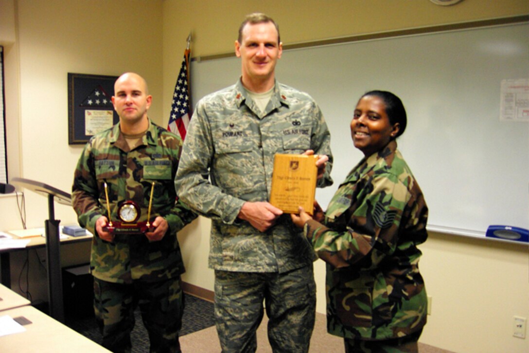 SEYMOUR JOHNSON AIR FORCE BASE, N.C. -- Tech. Sgt. Glenda Reeves, a member of the 916th Air Refueling Wing Security Forces, receives recognition for her seven years of service with the Reserve squadron.  Sergeant Reeves receives a going-away gift from Maj. Jeff Poupart, squadron command and First Sergeant Justin Patton.  Sergeant Reeves moves to the 916th Mission Support Group to take over as the new group career assistance advisor.