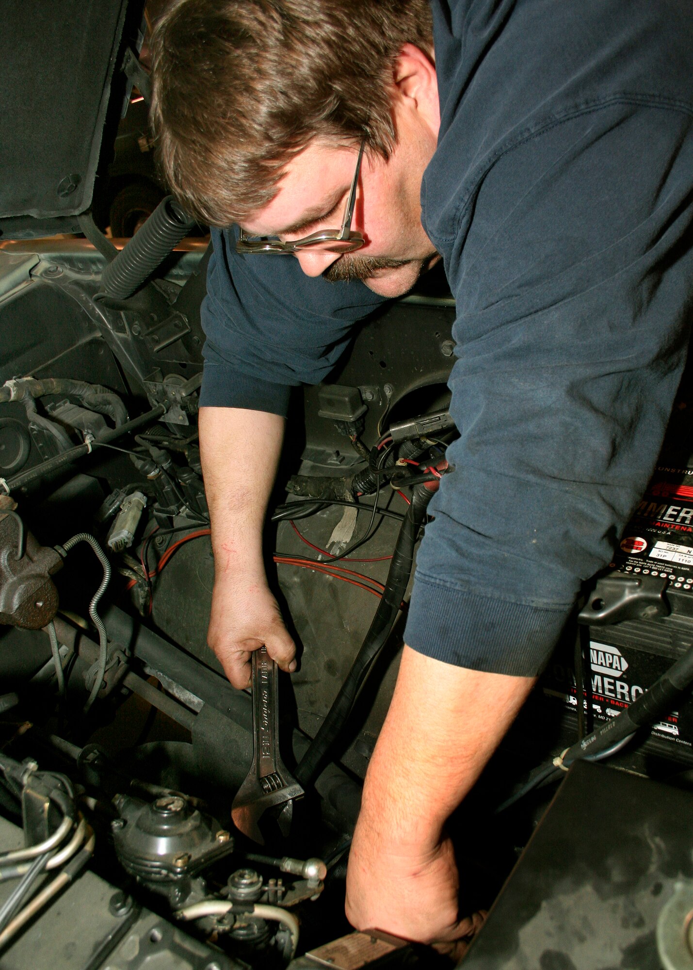 GRISSOM AIR RESERVE BASE, Ind., -- Mike Nero, a vehicle mechanic, tightens a bolt on the engine of a truck at the vehicle maintenance facility at Grissom.  Mike is one of the hundreds of civilian and contractor employees at the base.  Grissom is one of the largest employers in the region and has an annual economic impact of $100 million. (U.S. Air Force photo/Tech. Sgt. Patrick M. Kuminecz)