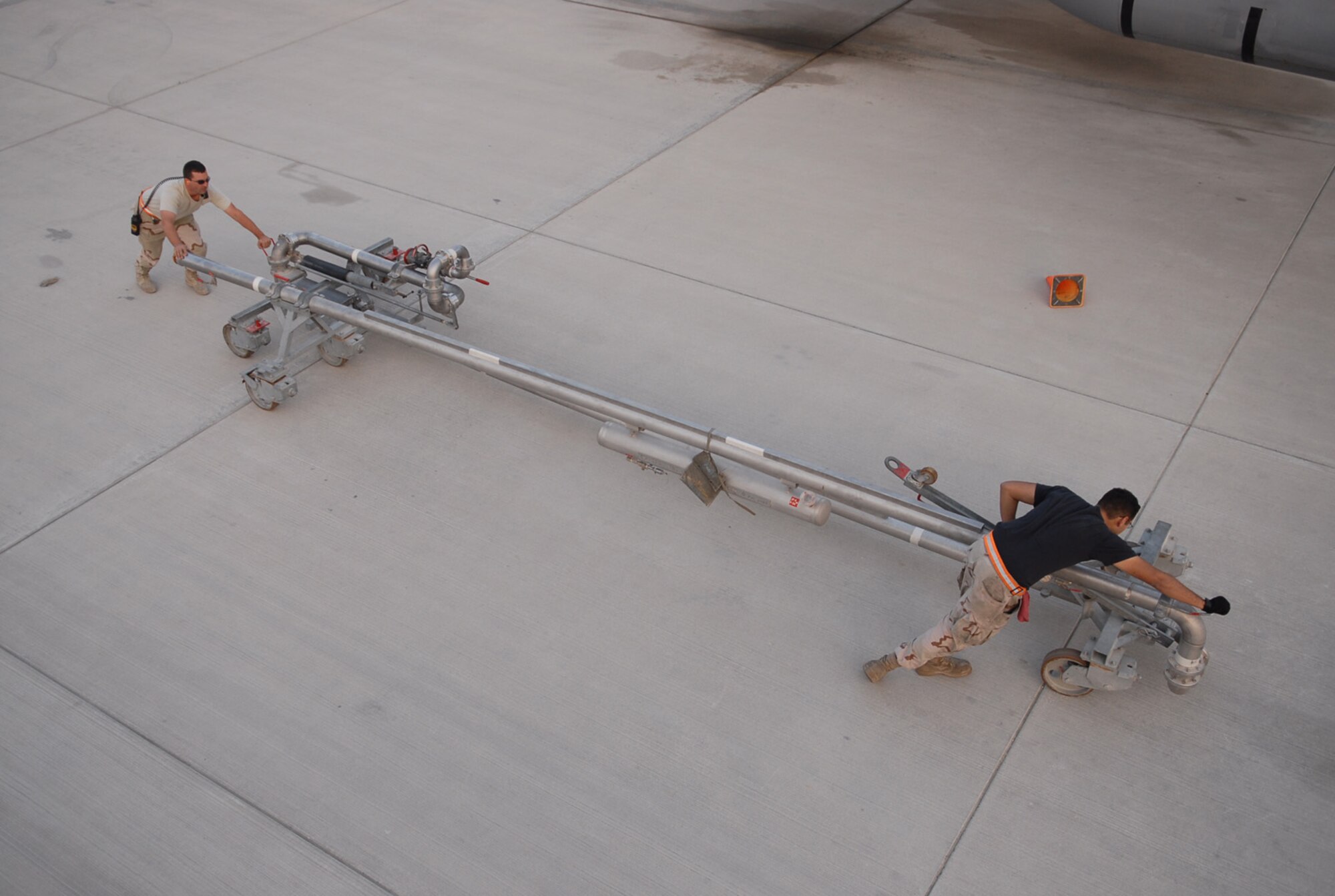 SOUTHWEST ASIA - Staff Sgt. Brian McCaslin (left), 379th Expeditionary Logistics Readiness Squadron, and Staff Sgt. Ruben Mariscal, 379th Expeditionary Aircraft Maintenance Squadron, recover the pantograph after refueling a KC-135 Stratotanker at a Southwest Asia air base Jan. 5. (U. S. Air Force photo/Staff Sgt. Douglas Olsen)