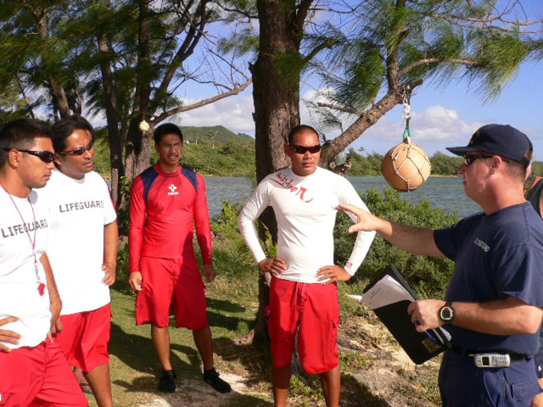 Lifeguards  (from left to right) Julius General, Glenn Bejerana, Roderick Casas, Rueben Cruz gather to receive instructions from Chief  Operations Specialist Douglas Samp of the U.S. Coast Guard during search and rescue training at Jeff’s Pirates Cove beach Dec. 13. (Courtesy photo by Lee Putnam)