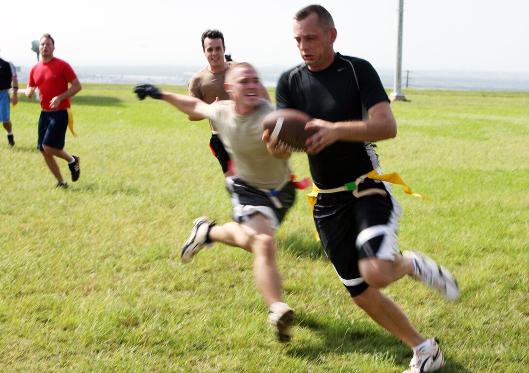 MARINE CORPS BASE, CAMP H.M. SMITH, Hawaii -- Right,  Douglas Dixon, G-6 Marauders' quarterback, runs his hardest for the end zone with SOCPAC defender, Jason Carrier right on his tail. Try as he might, Dixon was no match for Carrier's speed.