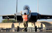 A weapons loader marshals an F-15A Eagle into position Jan 9. at Hickam Air Force Base, Hawaii. The F-15s, from the 199th Fighter Squadron, 154th Wing, Hawaii Air National Guard, have not flown since the Air Force grounded their F-15 fleet Nov. 3, 2007. Air Combat Command cleared a portion of its F-15 A-D models to begin flying today. (U.S. Air Force photo/ Tech. Sgt. Shane A. Cuomo)