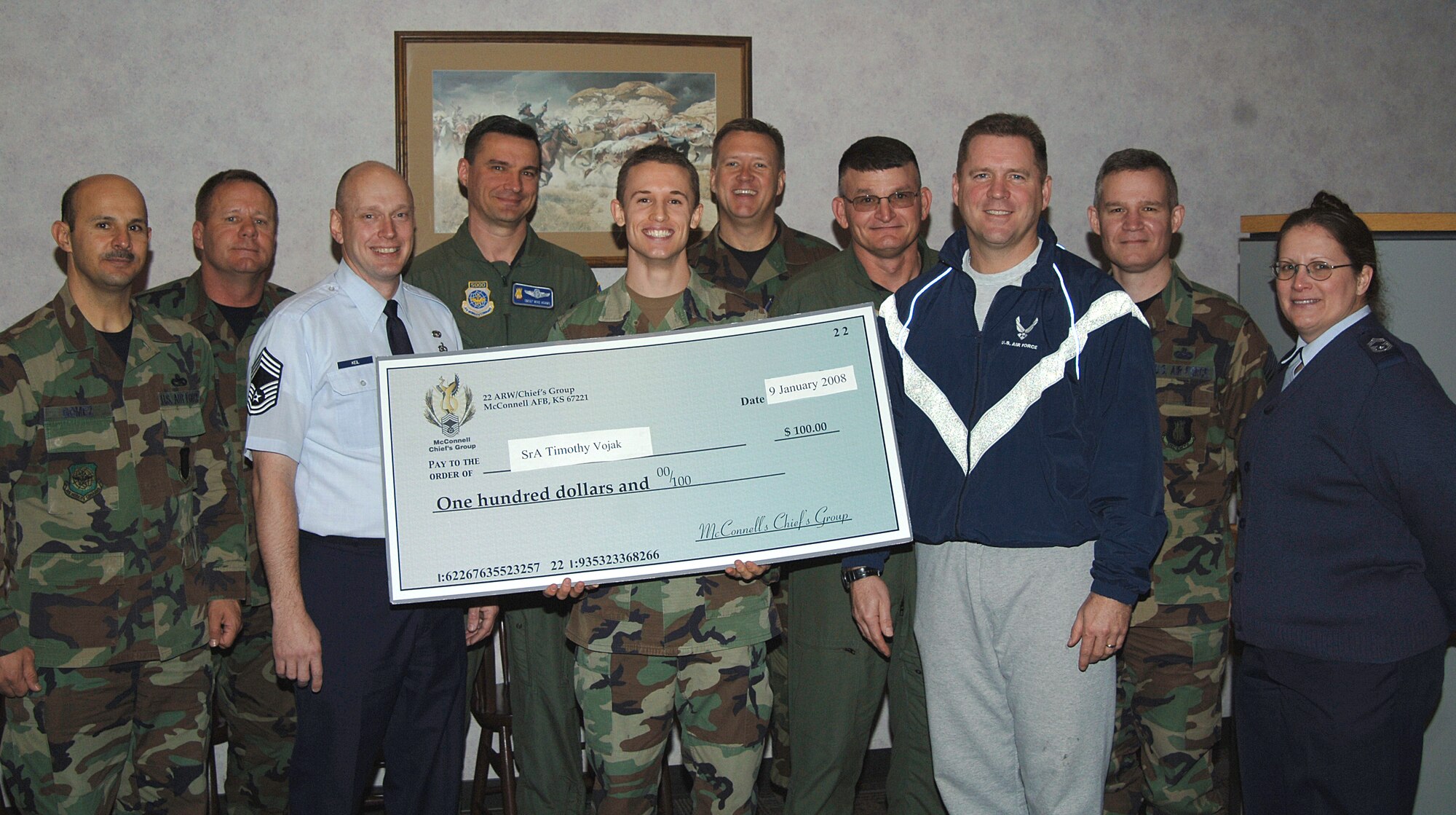 Members from the McConnell Chief’s Group present a $100 scholarship to Senior Airman Timothy Vojak, Jan 9, at the Chisolm Trail dining facility for his winning essay entry. Scholarships are awarded by the chiefs group quarterly; up to eight scholarships per year. The chief’s group actively supports the enlisted community by providing the opportunity to receive assistance towards furthering Airmen’s education. Scholarship participants are restricted to active duty members E-1 to E-6. Applications and more information can be found outside the education office at the Robert J. Dole center or people can contact Chief Master Sgt. Steve Herdler at 759-3605.  (Photo by Airmen 1st Class Jessica Lockoski)