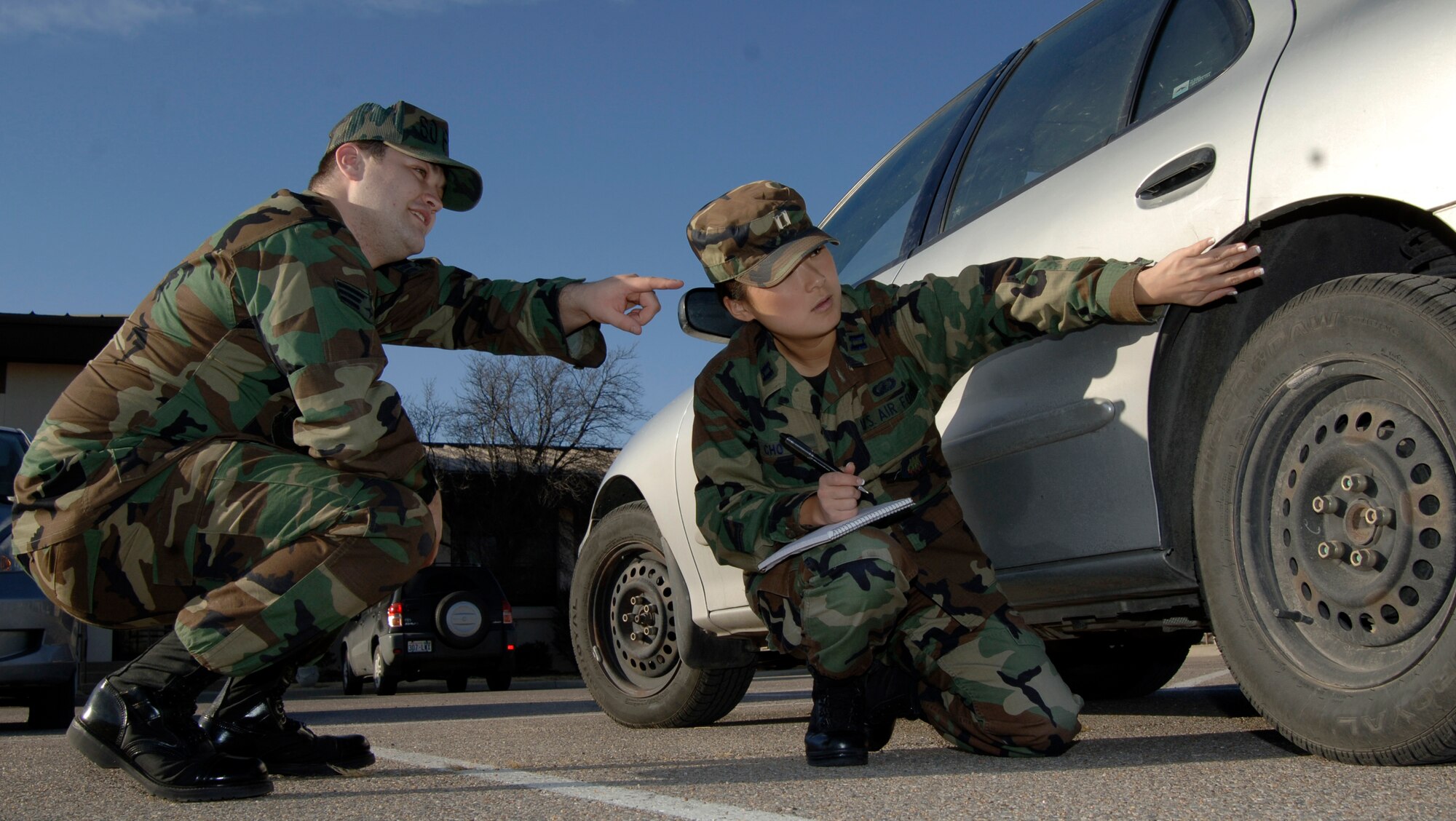 MCCONNELL AIR FORCE BASE, Kan. -- Capt. Dal Cho, 22nd Air Refueling Wing Judge Advocate, assess the damage done to Senior Airman Mitchell Jones, 22d Air Refueling Wing Judge Advocate, car at the Legal office, Dec. 20. Civil law is a section of the Legal office that handles such things as environmental issues, building regulations, contracts and vendors on base.  (Photo by Airman 1st Class Roy Lynch III)