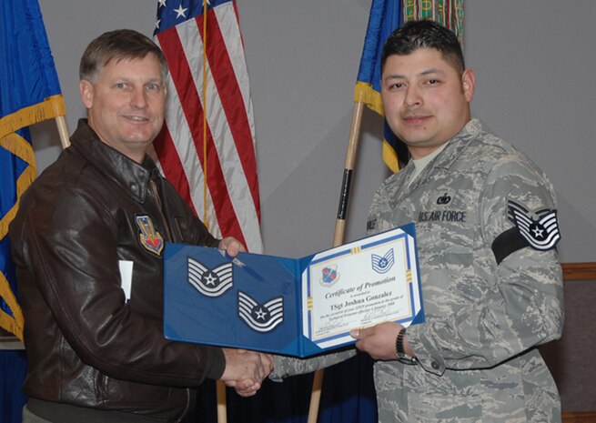 Newly promoted Tech. Sgt. Joshua W. Gonzalez, the 99th Logistics Readiness Squadron fuels support assistant noncommissioned officer in charge, receives his official promotion from the 99th Air Base Wing commander, Col. Michael Bartley, as part of the Air Force’s Stripes for Exceptional Performer promotion program. (U.S. Air Force photo by Staff Sgt. Scottie McCord)