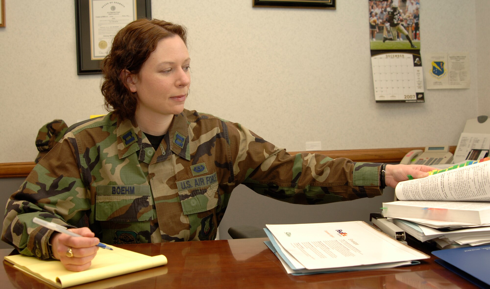 MCCONNELL AIR FORCE BASE, Kan. -- Capt. Kellyann Boehm, 22nd Air Refueling Wing Judge Advocate, searches through a law book at the Legal office, Dec. 19. The Legal office deals with tax preparation and saved McConnell members over $100,000 dollars in fees last year.  (Photo by Airman 1st Class Roy Lynch III)
