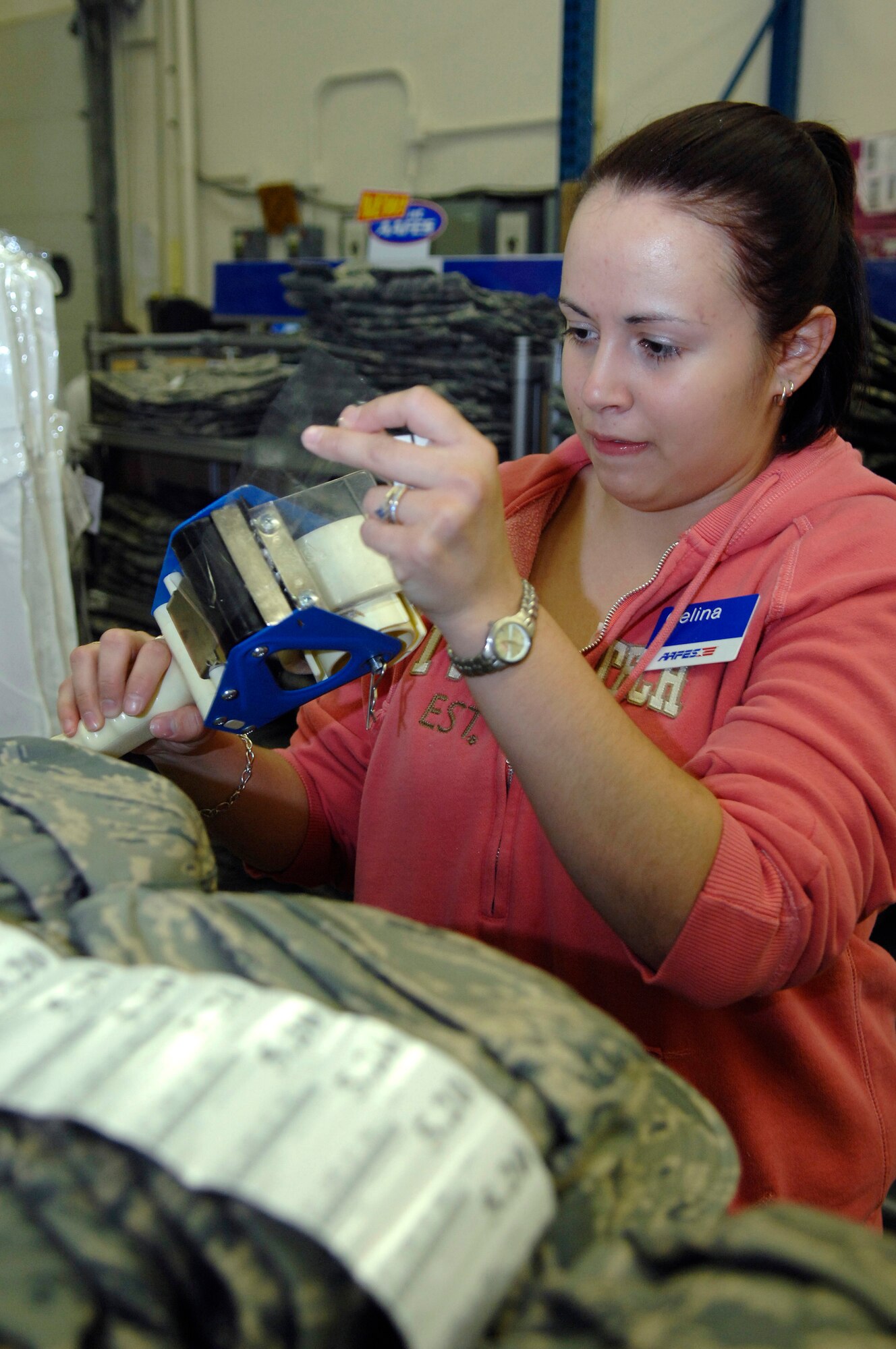 Celina Alamos, a worker for the Army and Air Force Exchange Service (AAFES) and wife of Airman 1st Class Jancey Alamos, from the 28th Security Forces Squadron, attaches price labels to shelves stocked with new Airman Battle Uniforms (ABU) at Ellsworth Air Force Base, S.D., Jan. 09, 2008.  The ABU will be available for purchase to the general base population for the first time starting Friday at 9 A.M., for more information contact AAFES at 923-4774.  (U.S. Air Force photo/Staff Sgt. Michael B. Keller)