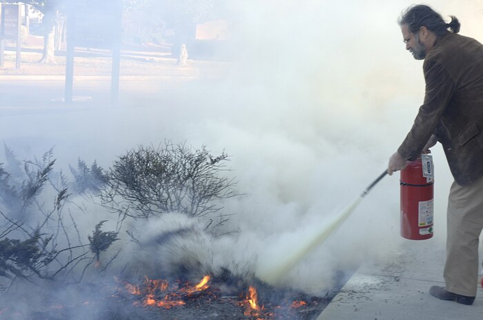 Dave "Smokey" Williams, 437th Airlift Wing Public Affairs multimedia manager, noticed smoke coming from the side of building 302. Jan. 2. He immediately grabbed the nearest fire extinguisher, and controlled the fire preventing it from spreading. (U.S. Air Force photo Staff Sgt. April Quintanilla)