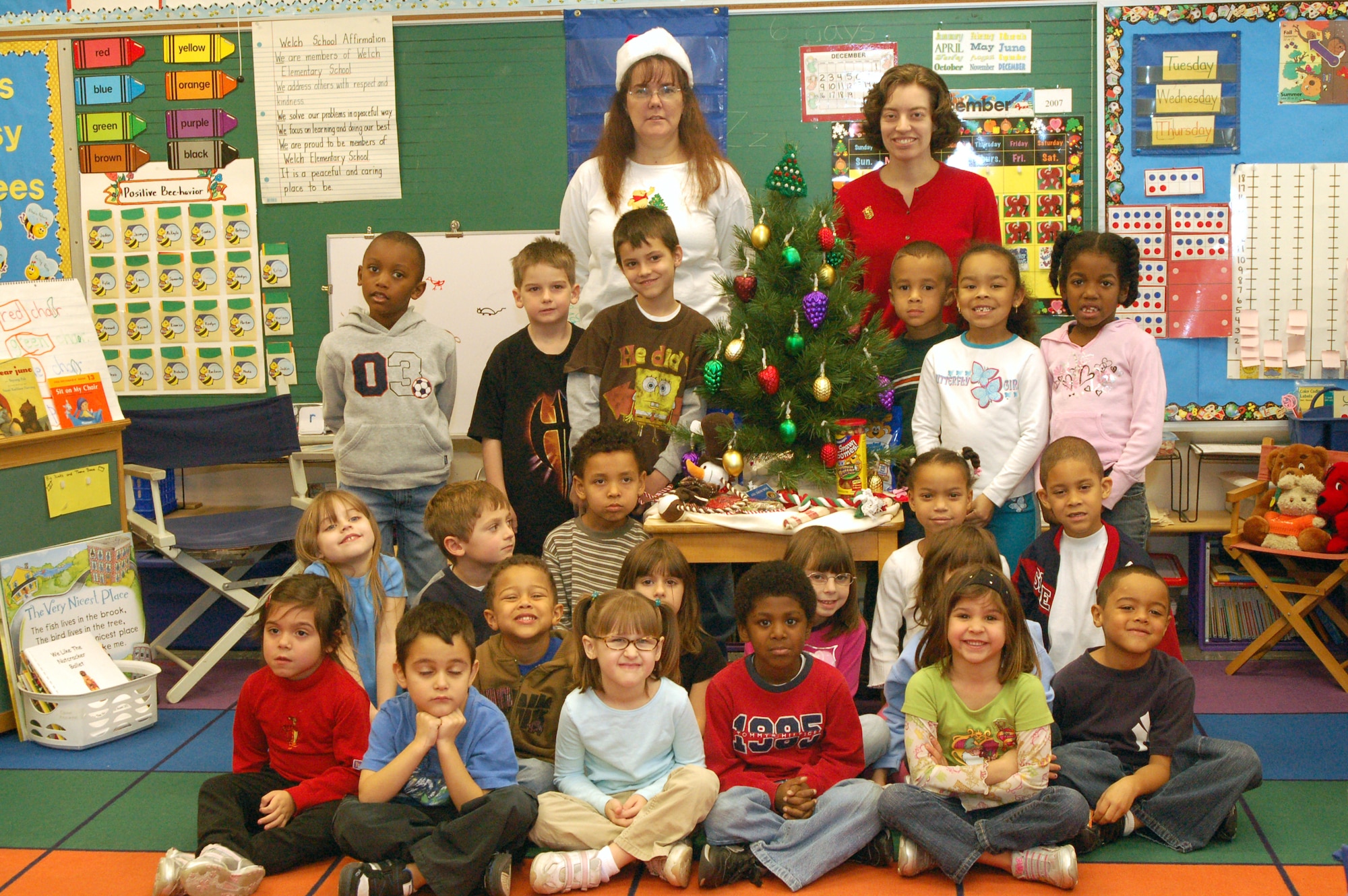 (Left to right) Corey Mears and Rhona Bassett's kindergarten class at the Major George Welch Elementary School poses in front of the Christmas tree with treats and items that were donated to the Kent Count Society for the Prevention of Cruelty to Animals.