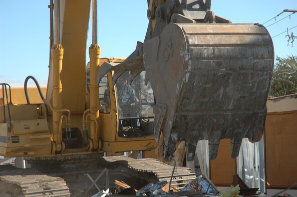 Hughie Palmer, Marshall Brothers Contracting contractor, uses a Trackhoe to demolish building 656, the former office of special investigations building, here Jan. 4, 2008.  The demolition is part of a project by the Air Education and Training Command to  dispose of under-utilized buildings that are beyond feasible renovation, which saves on energy consumption and costs.  (U.S. Air Force photo/Staff Sgt. Timothy R. Capling)