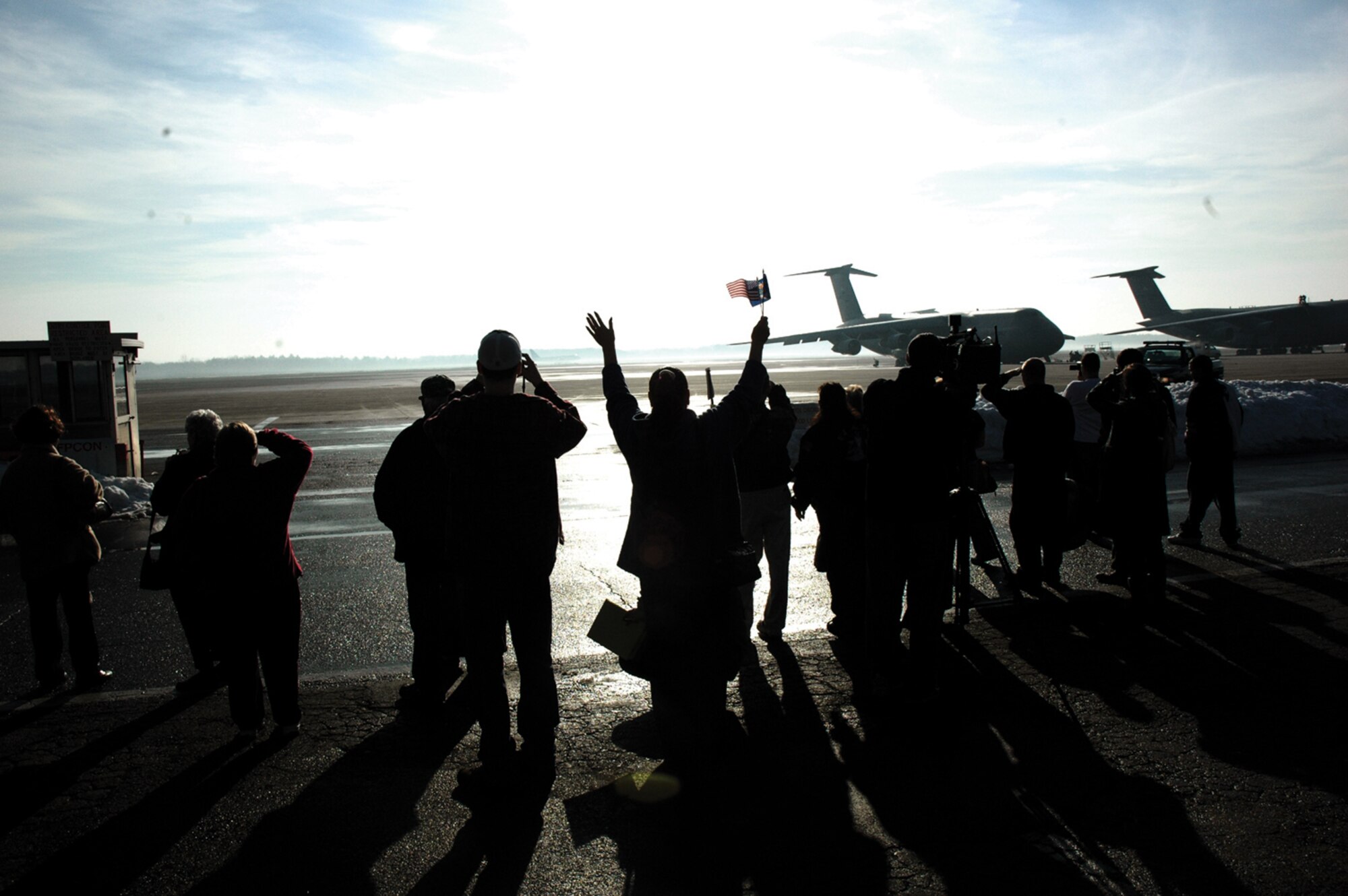 A group of family members wave as a commercial jet carrying Airmen from the 439th Aeromedical Staging Sqaudron bound for Iraq takes-off from the runway at Westover Air Reserve Base, Mass. (U.S. Air Force photo/Master Sgt. Tom Allocco)
