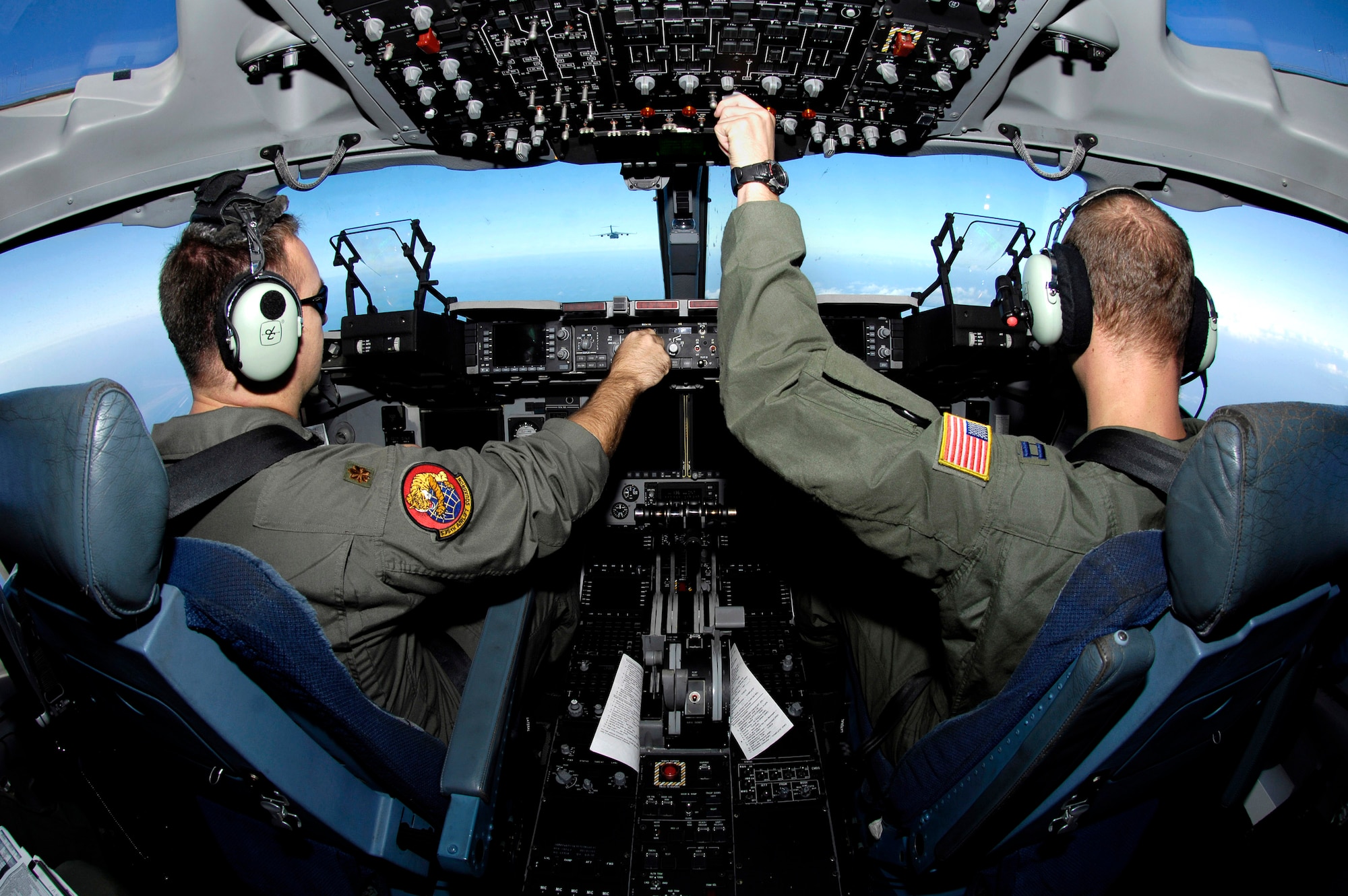 Maj. Pete Axtell and Capt. Mark Fischer fly in a C-17 Globemaster III two-ship formation Jan. 7 over Oahu, Hawaii. The Airmen, from the 535th Airlift Squadron, Hickam Air Force Base, Hawaii, are conducting airdrops at the Kahuku Training range as part of their currency training. (U.S. Air Force photo/Tech. Sgt. Shane A. Cuomo) 