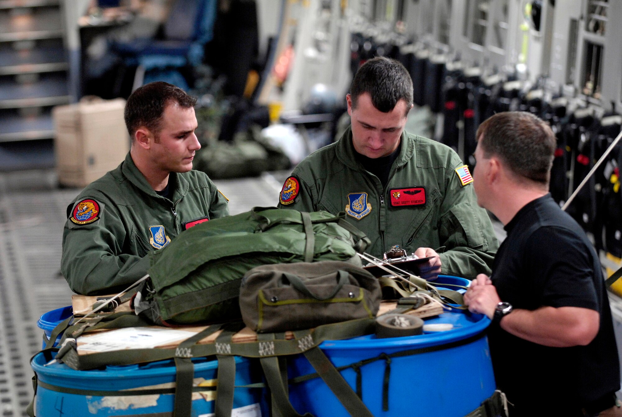 Staff Sgts. Ryan Boehm, Scott Stueven and Allen Culbreth go over a joint airdrop inspection form on a C-17 Globemaster III Jan. 7 at Hickam Air Force Base, Hawaii. The 535th Airlift Squadron Airmen are participating in a local two-ship airdrop training mission as part of their currency training. (U.S. Air Force photo/Tech. Sgt. Shane A. Cuomo) 
