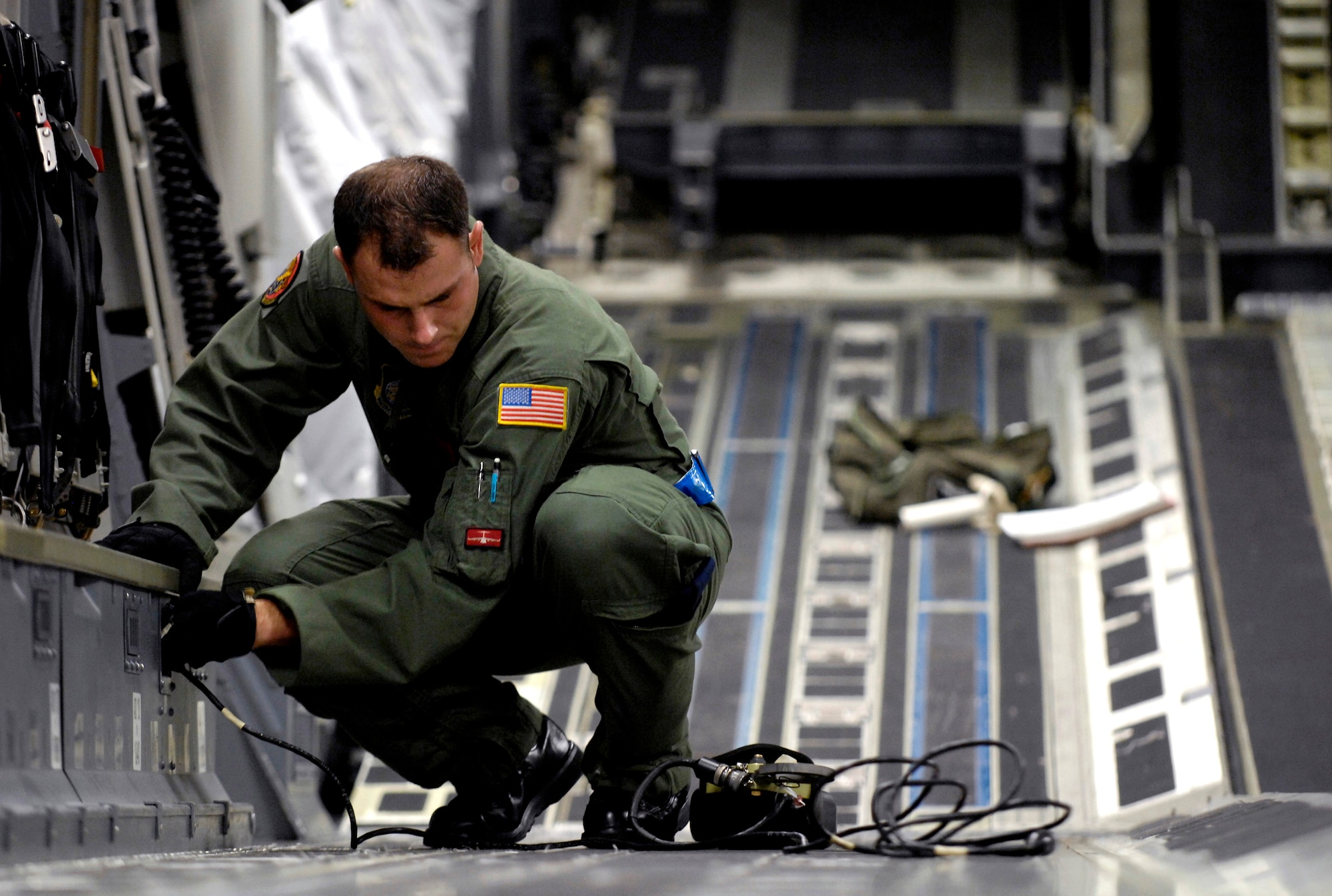 Staff Sgt. Ryan Boehm connects a gate release mechanism on his C-17 Globemaster III for an airdrop training mission Jan. 7 at Hickam Air Force Base, Hawaii. Sergeant Boehm is a loadmaster for the 535th Airlift Squadron. The mission is part of a local two-ship airdrop currency training mission. (U.S. Air Force photo/Tech. Sgt. Shane A. Cuomo) 