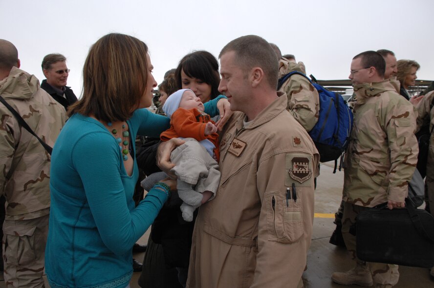 Maj. Kevin Cruikshank, a pilot with the 4th Fighter Squadron, holds his son for the first time at the unit's homecoming Jan.8.  The 4th FS deployed to Balad Air Base, Iraq in August and flew approximately 1,800 missions in support of ground forces in Operation Iraqi Freedom.  (U.S. Air Force photo by Alex Lloyd)