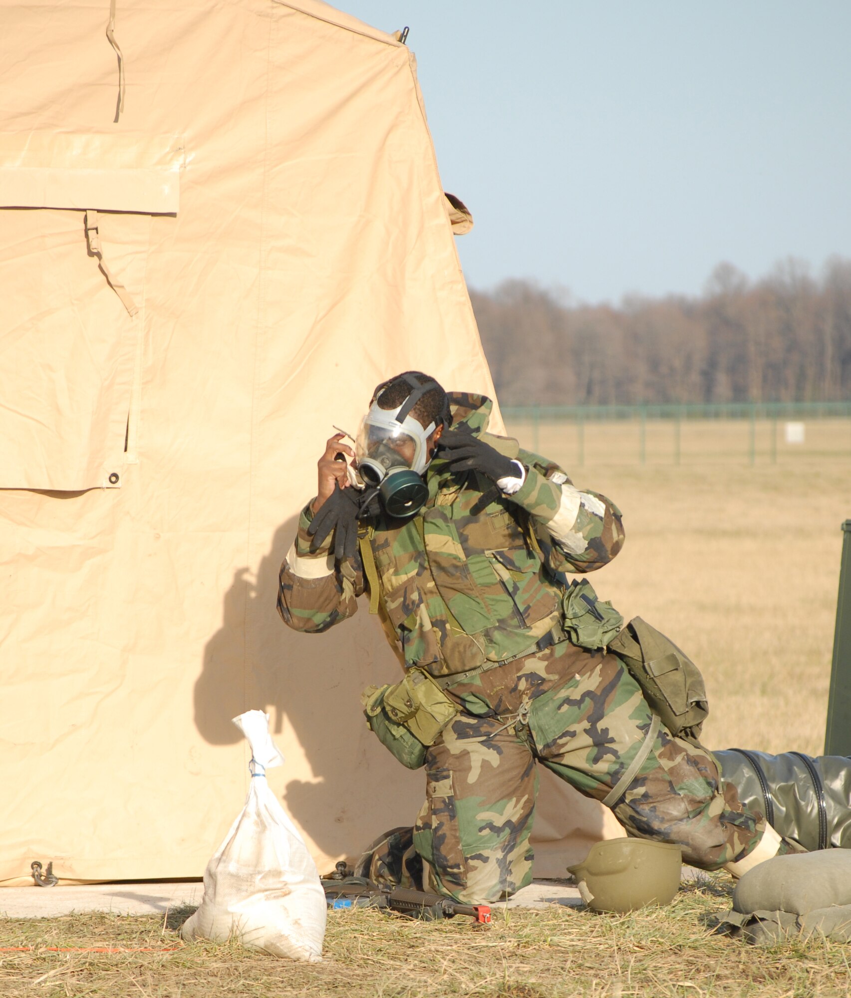 Staff Sgt. Martin Davis, 436th Services Squadron, removes his gas mask during the Dover Air Force Base Haunted House Battle Axe exercise Jan. 7. During the exercise, alarm conditions varied. At this time, the alarm condition went from 'alarm black' to 'alarm yellow,' which permitted Sergeant Davis to remove some of his protection. (U.S. Air Force photo/Tech. Sgt. Kevin Wallace)