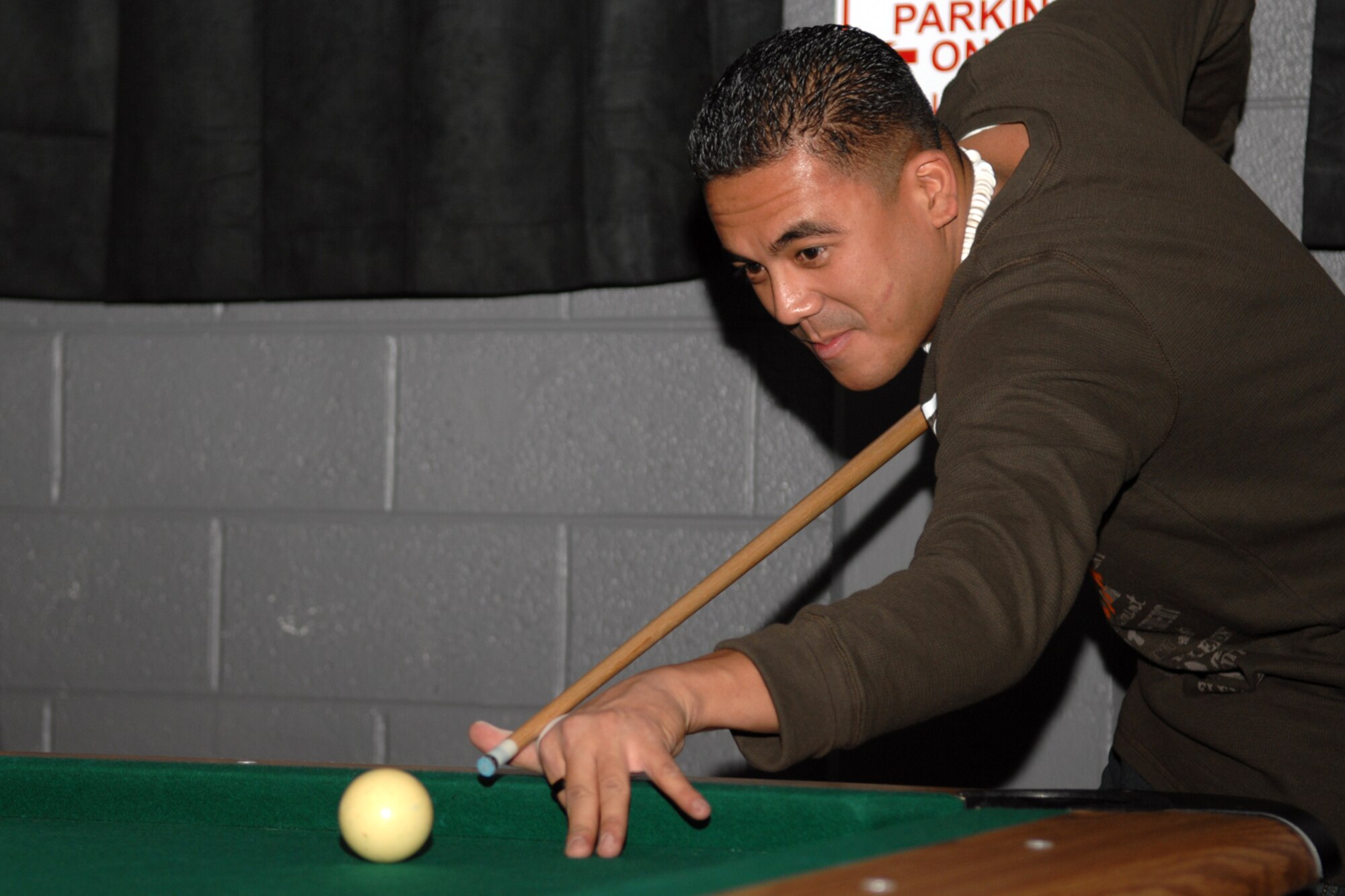 Airman 1st Class Luis Lopez, 49th Aircraft Maintenance Squadron, prepares to strike the cue ball at the Airman's Activity Center, Holloman Air Force Base, N.M. The newly renovated Airman's Activity Center offers a place for airmen to listen to music, dance, play games, relax, and have fun. (U.S. Air Force photo/Airman 1st Class Jamal D. Sutter)