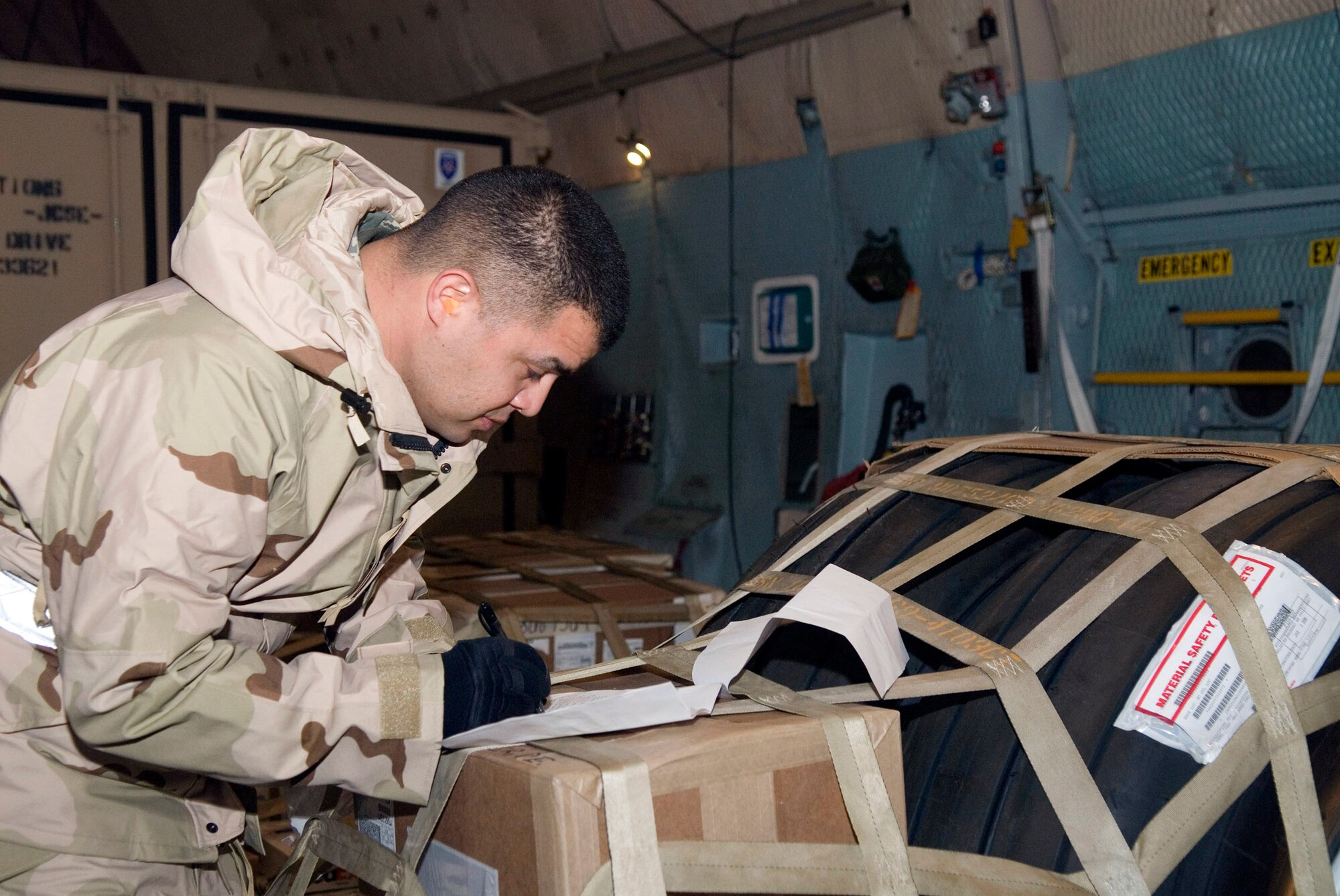 Tech. Sgt. Daniel Varley inventories cargo prior to off loaded it from a C-5 Galaxy Jan. 7 at Balad Air Base, Iraq. The inventory is done to ensure the correct cargo pallets are downloaded. Sergeant Varley, a 332nd Expeditionary Logistics Readiness Squadron air transportation specialist, is deployed from Lackland Air Force Base, Texas. (U.S. Air Force photo/Staff Sgt. Joshua Garcia) 
