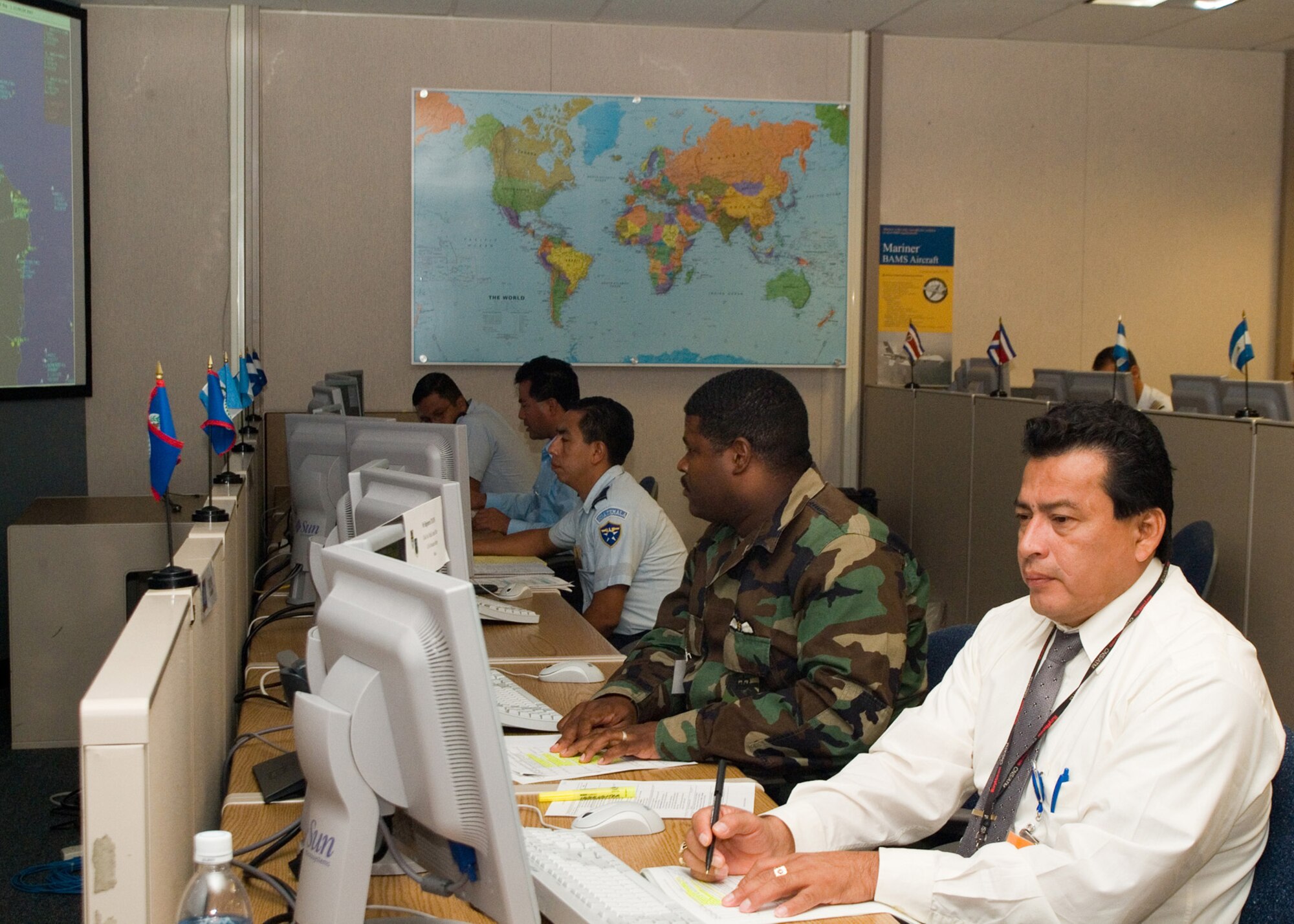 Civilian and military air traffic management specialists from various Latin American nations try out individual work stations while participating in a Regional Coordination Center demonstration held in Eagan, Minn., last August.  Fifteen nations attended and seven fully participated in the demonstration of the mocked-up coordination center.

