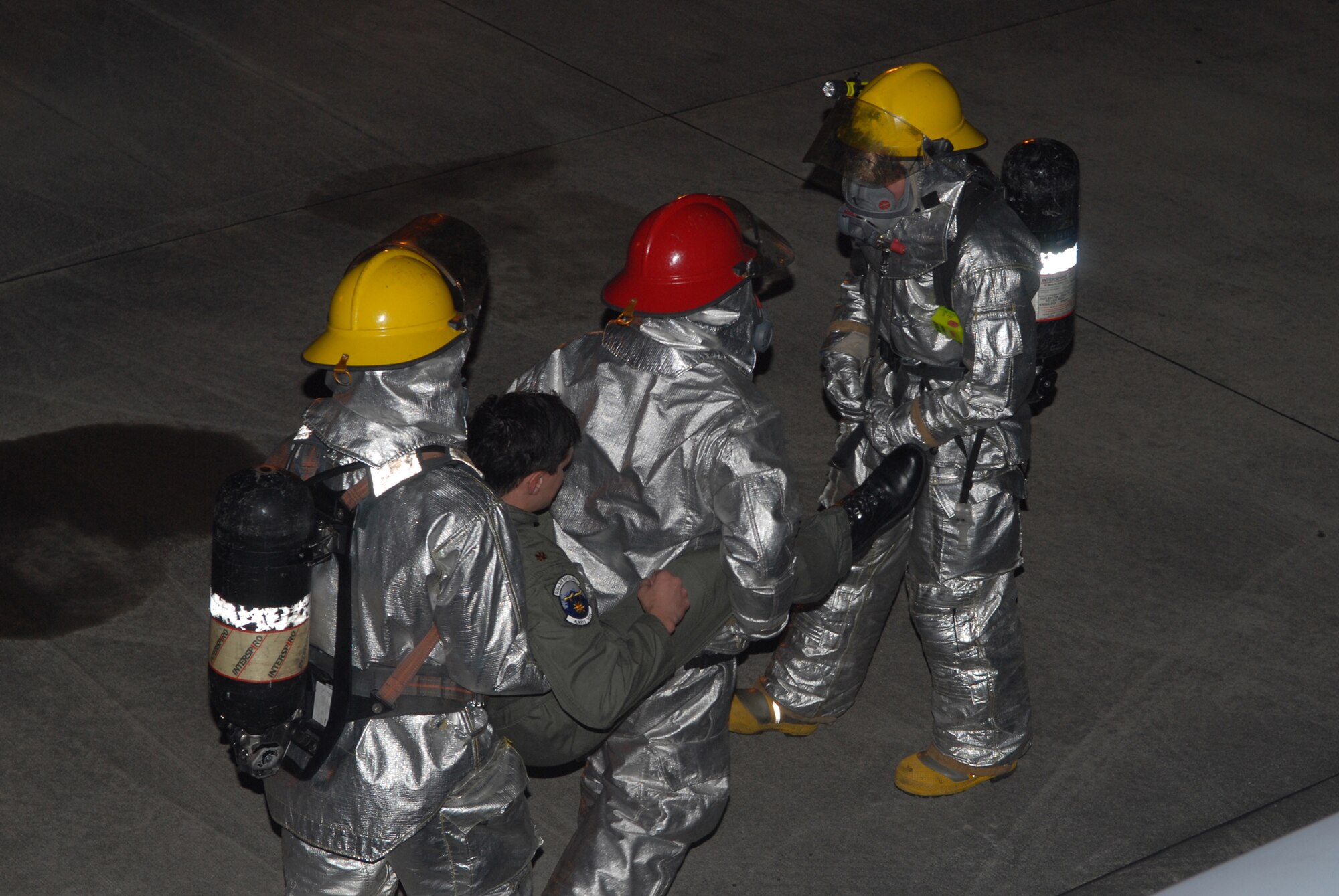 Firefighters assigned to the 18th Civil Engineer Squadron, work together to safely carry unconscious co-pilot Maj. Michael Kallai, 909th Air Refueling Squadron, out of a KC-135 Stratotanker, during Local Operational Readiness Exercise Beverly High 08-3 at Kadena Air Base, Japan, Jan. 9, 2007. The 18th Wing conducted the exercise from Jan. 7 to 11 to test Airmen's ability to respond in contingency situations. (U.S. Air Force photo/Staff Sgt Chrissy FitzGerald)
