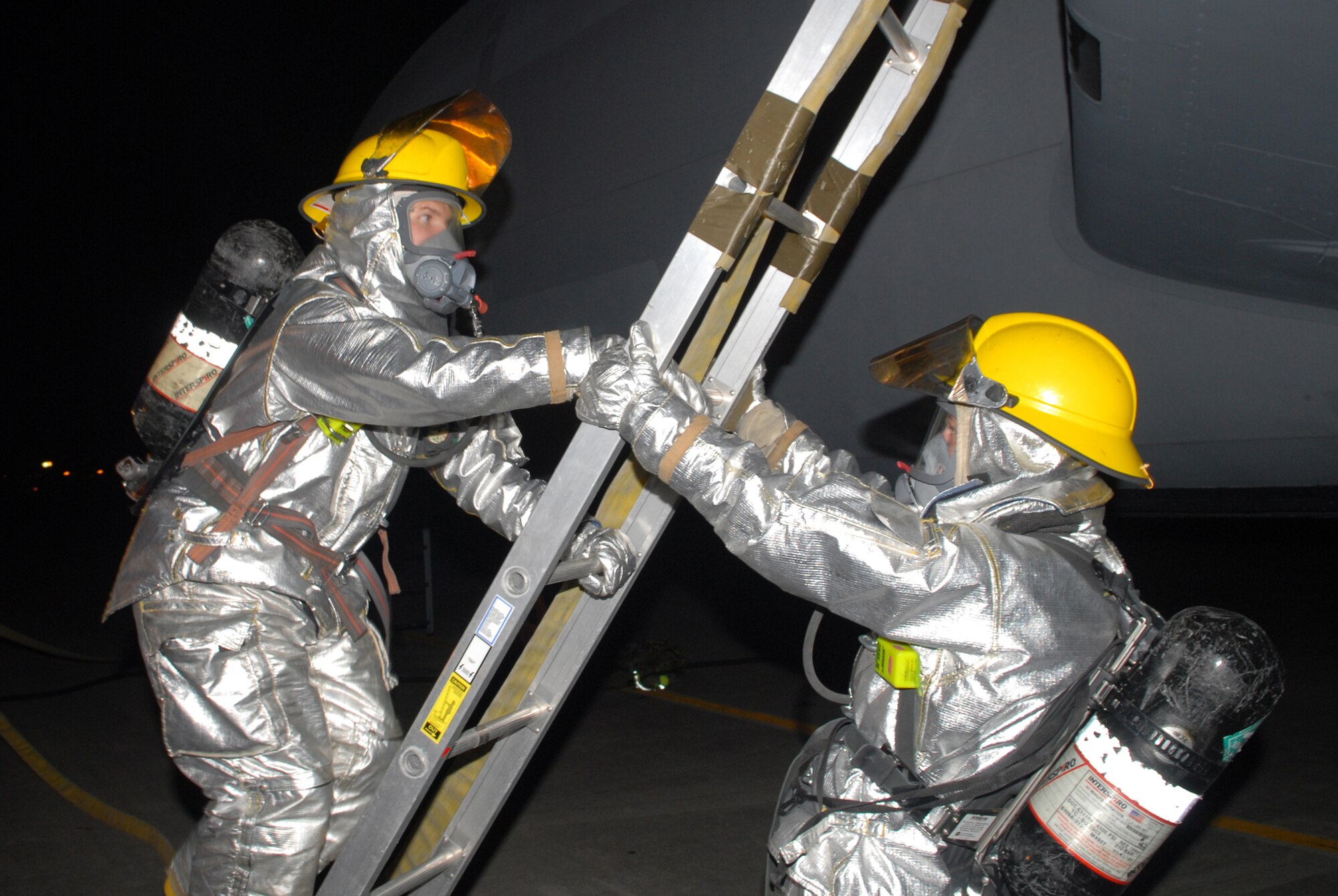 Firefighters assigned to the 18th Civil Engineer Squadron, climb and secure a ladder so that they can extract aircrew from a KC-135 Stratotanker, during Local Operational Readiness Exercise Beverly High 08-3 at Kadena Air Base, Japan, Jan. 9, 2007. The 18th Wing conducted the exercise from Jan. 7 to 11 to test Airmen's ability to respond in contingency situations. (U.S. Air Force photo/Staff Sgt Chrissy FitzGerald)