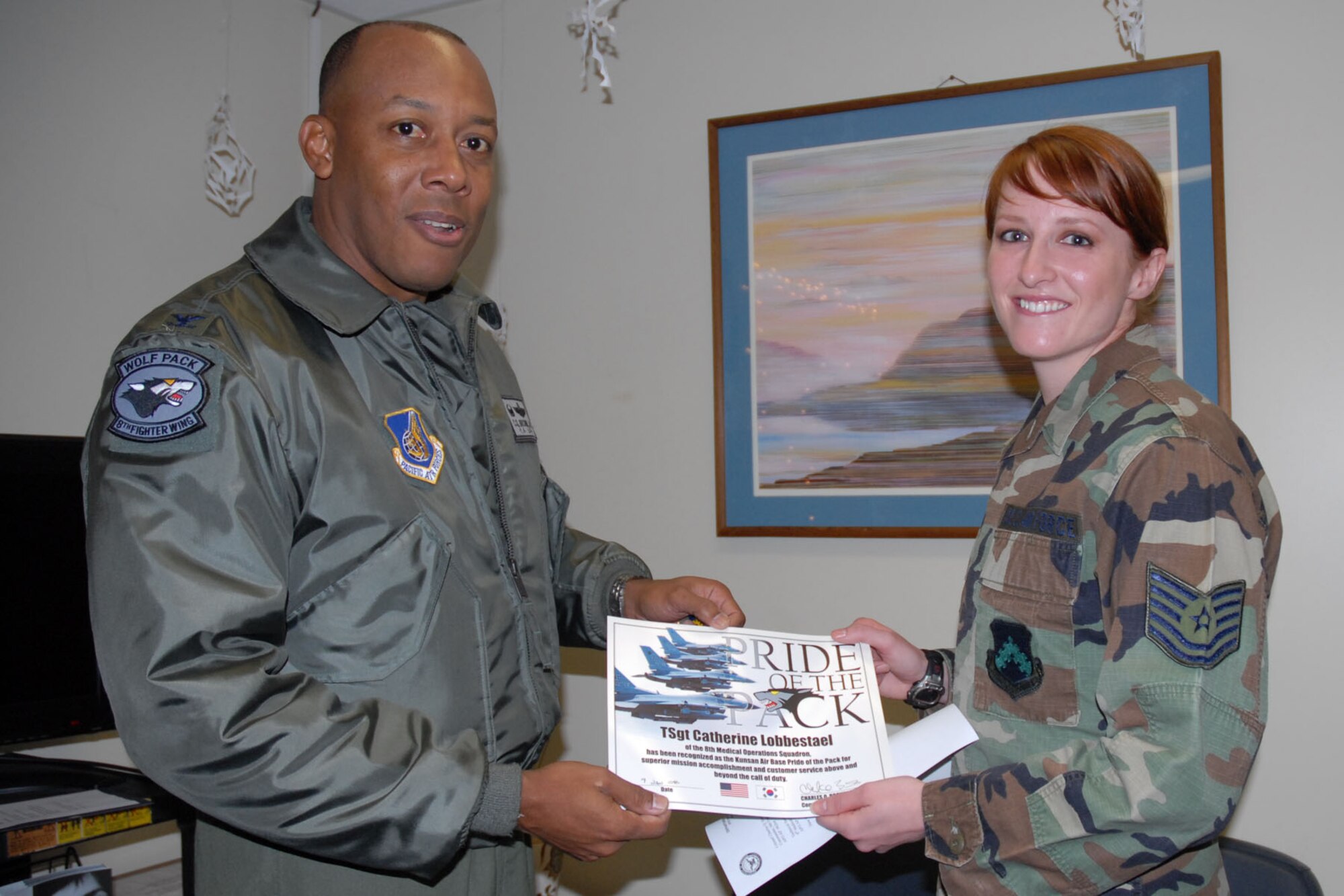 KUNSAN AIR BASE, South Korea -- Colonel CQ "Wolf" Brown, 8th Fighter Wing commander, congratulates Tech. Sgt. Catherine Lobbestael, 8th Medical Operations Squadron, NCO in charge of psychology here Jan. 9. Sergeant Lobbestael was selected as the 8th Fighter Wing's Pride of the Pack for the week of Jan 10. (U.S. Air Force photo/Staff Sgt. Araceli Alarcon)   