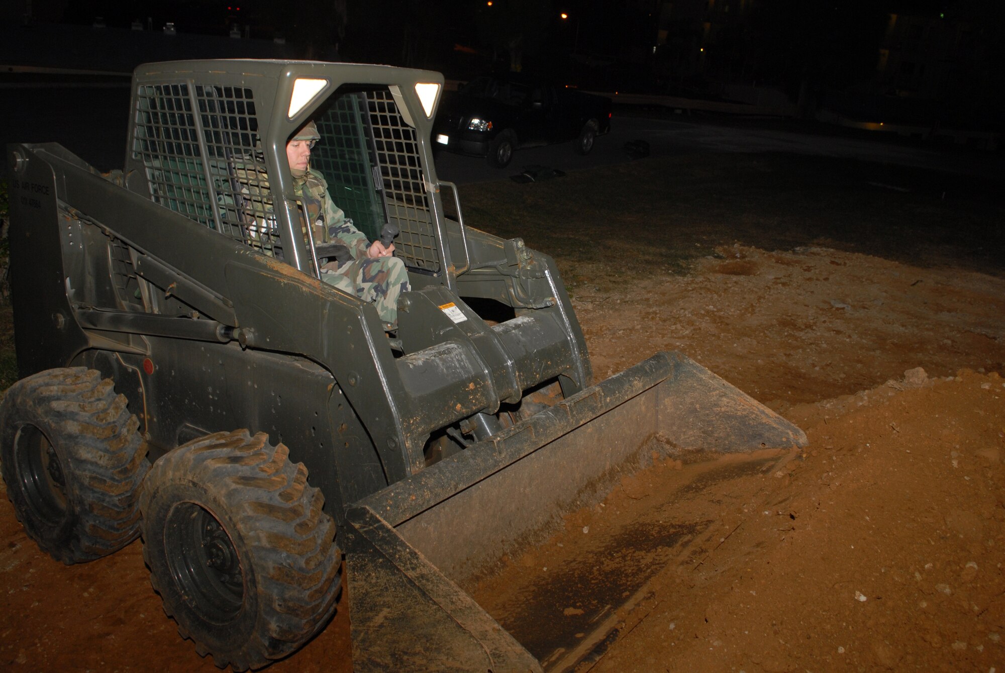 Staff Sgt. Daniel Rothenhoefer, 18th Civil Engineer Squadron, drives a bobcat as he builds a berm to hold 10,000 gallons of fuel during a Local Operational Readiness Exercise Beverly High 08-3 scenario at Kadena Air Base, Japan, Jan. 8, 2007. The 18th Wing conducted the exercise from Jan. 7 to 11 to test Airmen's ability to respond in contingency situations. (U.S. Air Force photo/Staff Sgt Chrissy FitzGerald) 