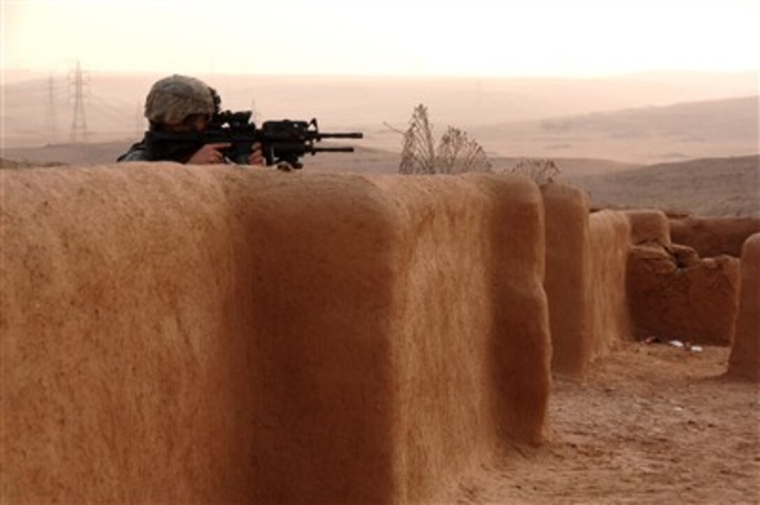 A U.S. Army soldier scans the immediate area from behind a dried mud wall as he provides security during a patrol in an area outside of Mosul, Iraq, on Jan. 4, 2008.  Soldiers from the Armyís 3rd Squadron, 3rd Armored Cavalry Regiment are patrolling in the area.  