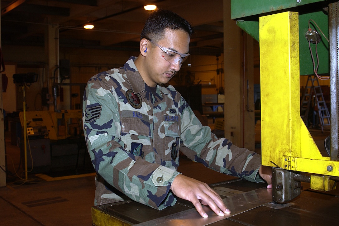 Staff Sgt. Joseph Baza, 36th Maintence Squadron, cuts a piece of sheet metal with a banding saw. Sergeant Baza was one of fifty Airmen in the Air Force to be selected for the Scholarships for Outstanding Airmen program. (U.S. Air Force photo/Airman 1st Class Carissa Morgan)
