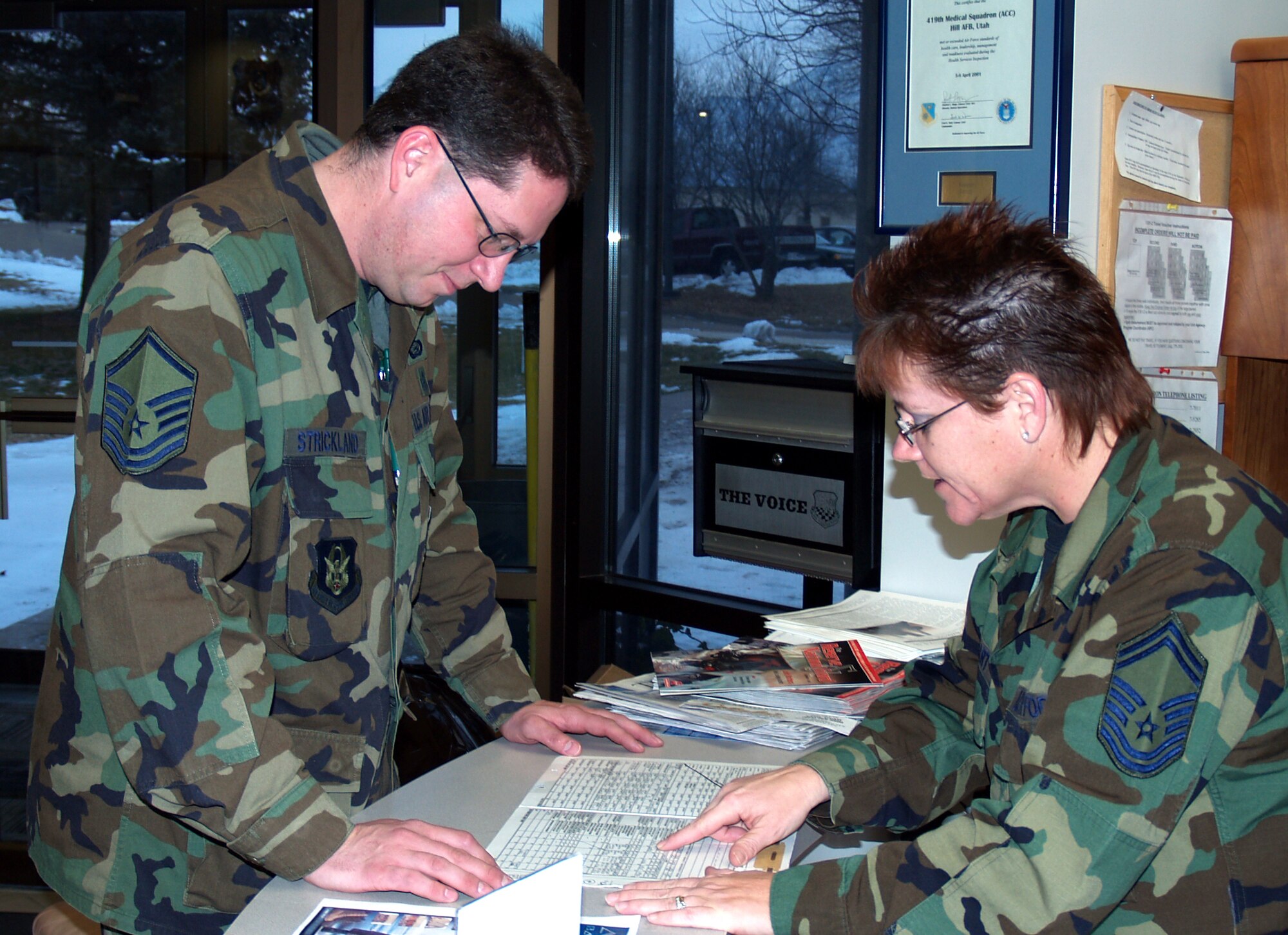 Senior Master Sgt. Kim Luckart and Master Sgt. Chris Strickland, both of the 419th Medical Squadron, review Strickland's medical records to ensure he has received the appropriate vaccinations prior to his upcoming overseas deployment.