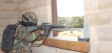 Staff Sgt. Felix Villarreal Jr., Combat Medic, acts as an opposition force during the final day of the Common Battlefield Airman Training Bridge field training excercise Dec. 20. Students use the skills taught to them throughout the week to maneuver into a village armed with training rounds and their rifle.  (U.S. Air Force photo by SSgt. Beth Del Vecchio) 