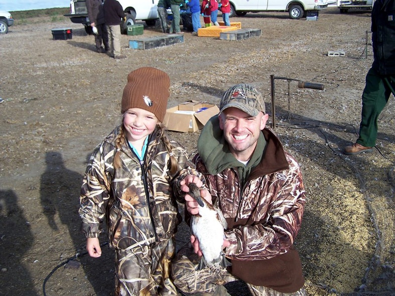 MINOT AIR FORCE BASE, N.D. -- Tech. Sgt. Leo Porcello, a missile alert facility manager with the 91st Operations Support Squadron, and his 5-year-old daughter, Marcellina, display a duck they banded Sept. 7, 2007 during a U.S. Fish and Wildlife Service project held at the J. Clark Salyer National Wildlife Refuge.  Along with banding, the birds have their age and sex determined, and then they are released. (Courtesy photo)