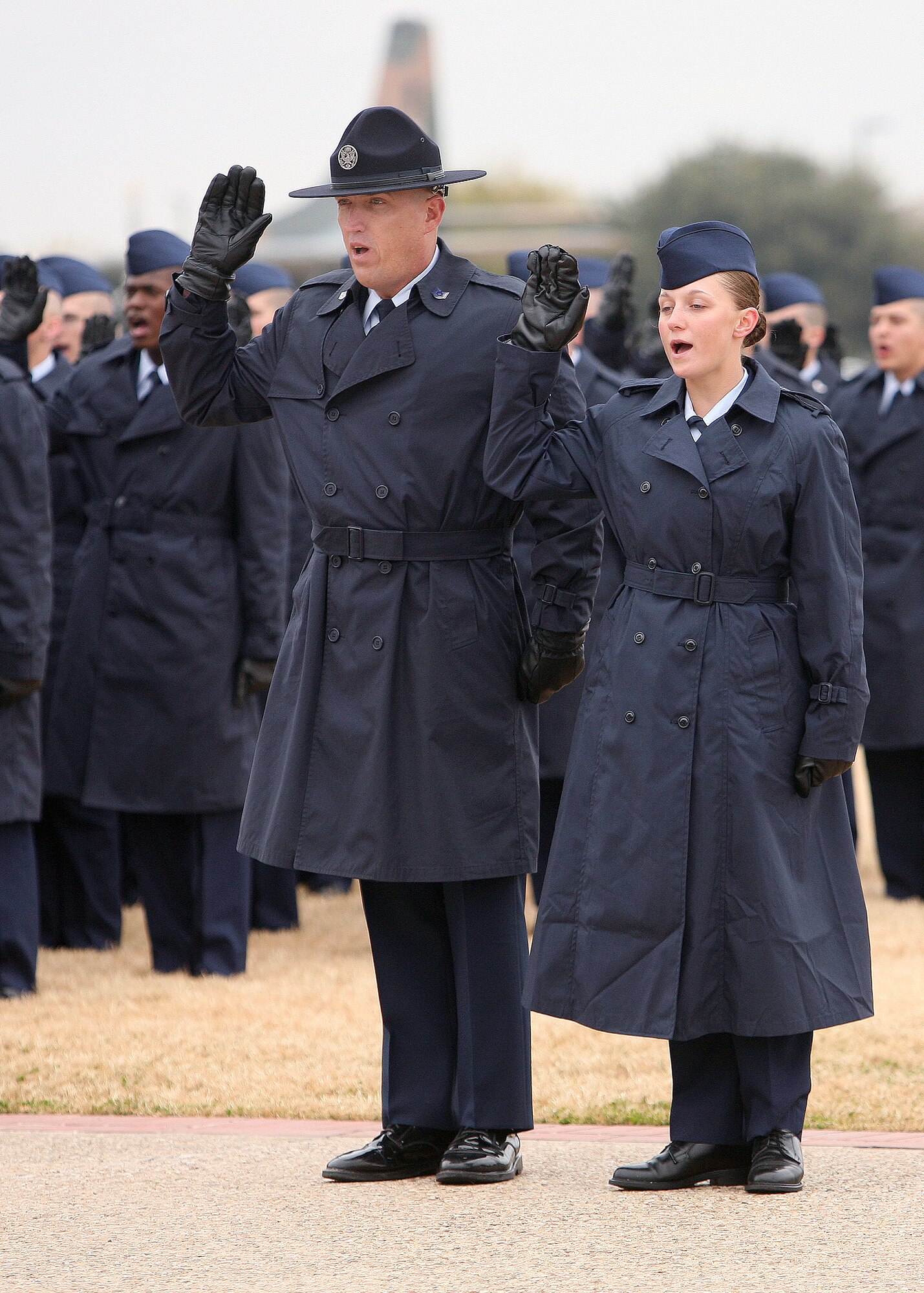 Re-enlistee, Tech. Sgt. Robert Rayburn, a military training instructor with the 331st Training Squadron, takes the Oath of Enlistment alongside his daughter, Airman Marlana Rayburn, during a basic military graduation parade at the Lackland Parade Grounds Jan. 4. (USAF photo by Robbin Cresswell) 