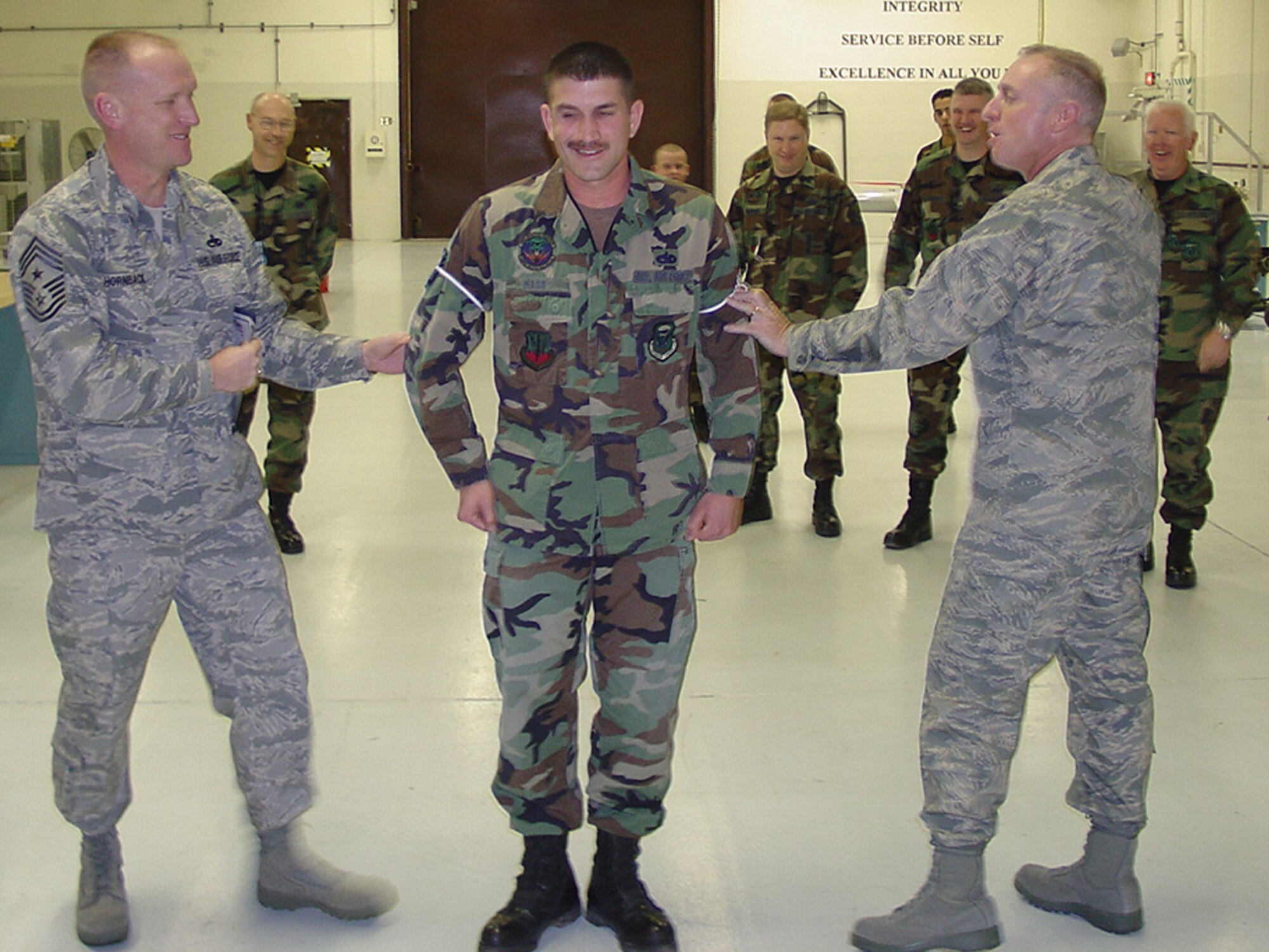 WHITEMAN AIR FORCE BASE, Mo. - Staff Sgt. John Hass, 509th Munitions Squadron, gets his new technical sergeant stripes put on by Brig. Gen. Garrett Harencak, 509th Bomb Wing commander, and Chief Master Sgt. Brian Hornback, 509th Bomb Wing command chief master sergeant during his Stripes for Exceptional Performance promotion Jan. 7. STEP promotions are reserved for staff sergeants to master sergeants, and presented selectees who have had approved recommendations by their commanders and meet the following criteria: candidates have performed outstanding in their duty section, are involved in off-duty activity in local communities, worked on self-improvement, and have been recognized for their job or non-duty performance. (Photo printed with permission of Chief Master Sgt. Brian Hornback)
