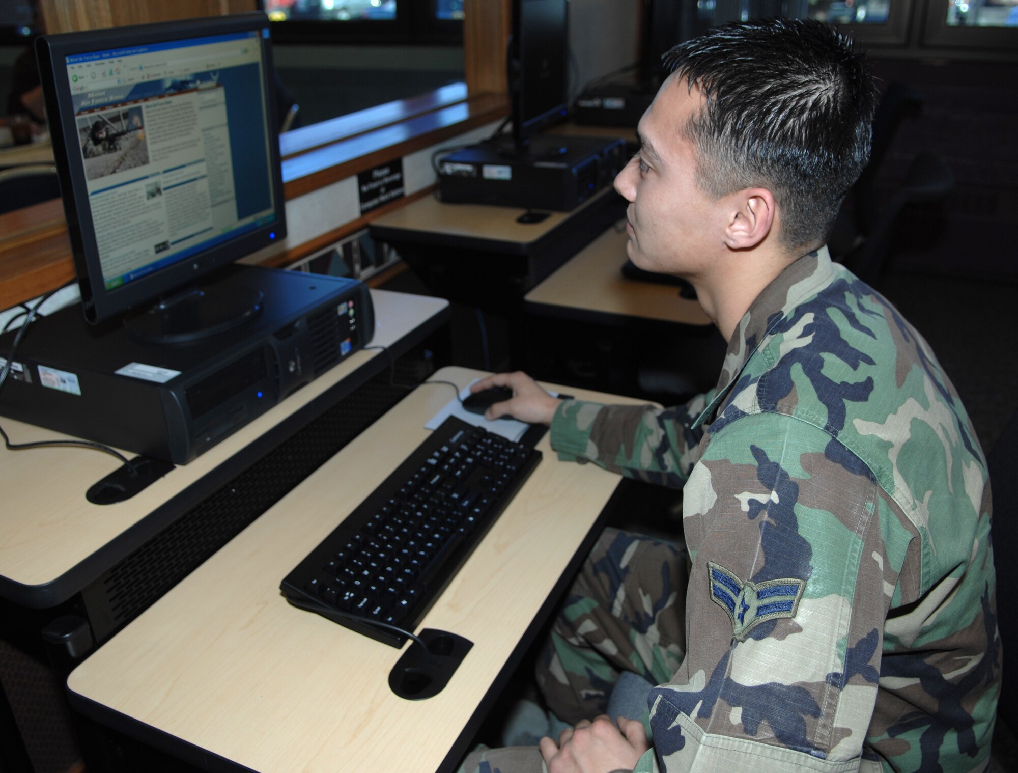 MINOT AIR FORCE BASE, N.D. -- In similar fashion to Col. Joel Westa, 5th Bomb Wing commander, Airman 1st Class William Schmit, 5th Logistics Readiness Squadron, takes advantage of the new cyber cafe at the Dakota Inn Dining Facility here Jan. 9. (U.S. Air Force photo by Senior Airman Stacey Moless)