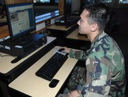 MINOT AIR FORCE BASE, N.D. -- In similar fashion to Col. Joel Westa, 5th Bomb Wing commander, Airman 1st Class William Schmit, 5th Logistics Readiness Squadron, takes advantage of the new cyber cafe at the Dakota Inn Dining Facility here Jan. 9. (U.S. Air Force photo by Senior Airman Stacey Moless)