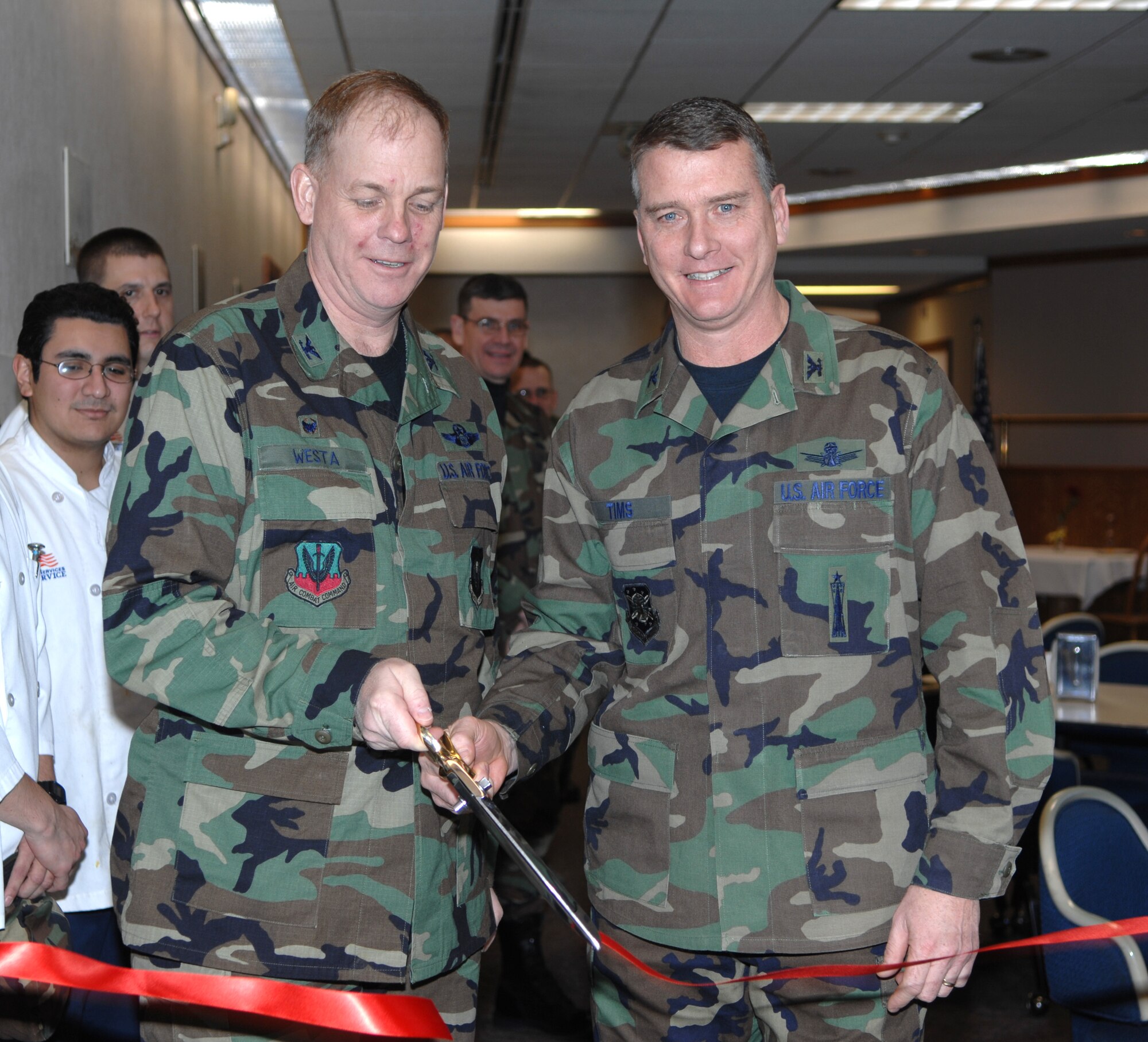 MINOT AIR FORCE BASE, N.D. -- Col. Joel Westa (right), 5th Bomb Wing commander, and Col. Greg Tims, 91st Space Wing vice commander, cut a ribbon to officially open the new cyber cafe at the Dakota Inn Dining Facility here Jan. 9. (U.S. Air Force photo by Senior Airman Stacey Moless)