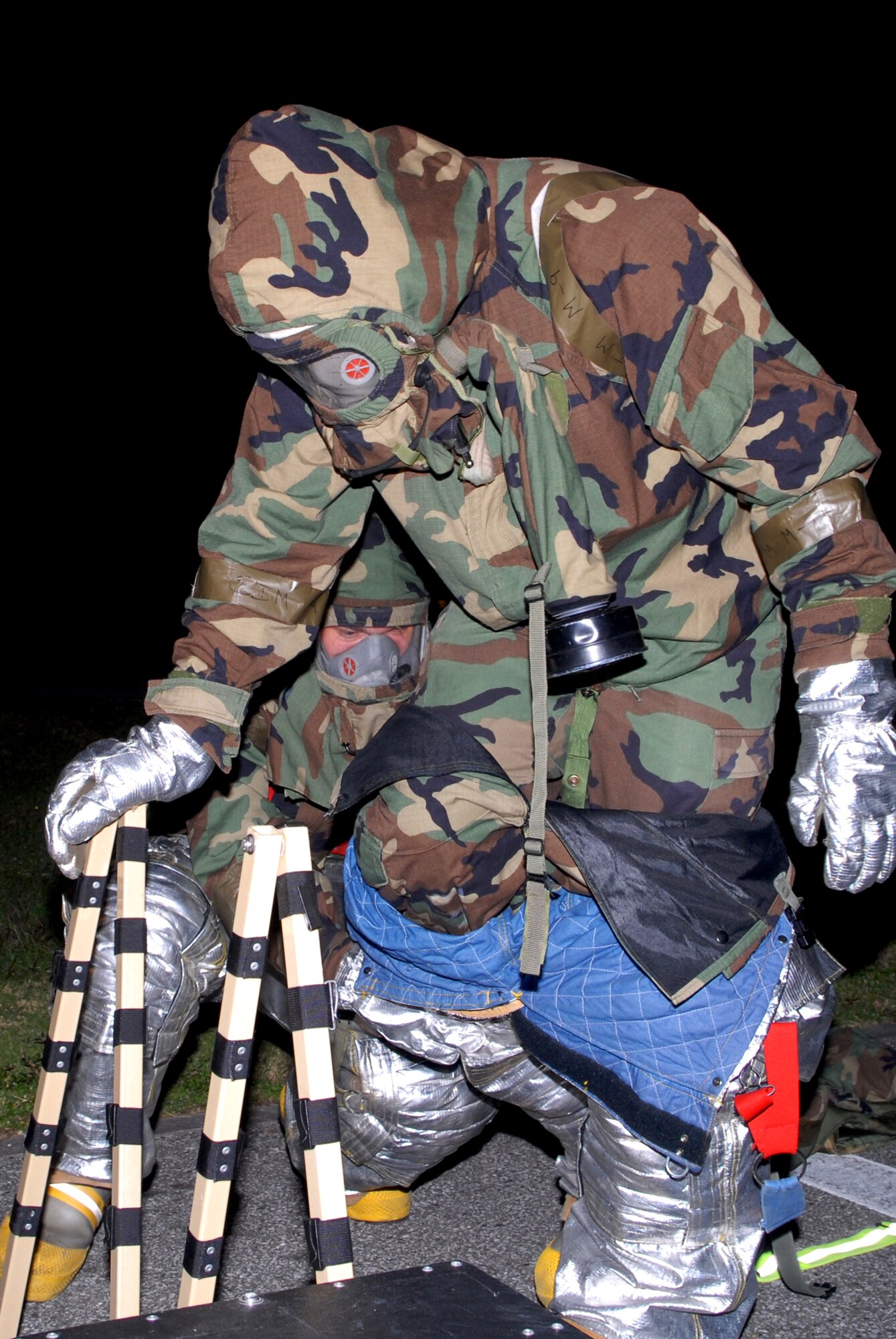 Firefighters assigned to the 18th Civil Engineer Group assist each other with each station of a contamination control area, during Local Operational Readiness Exercise Beverly High 08-3 at Kadena Air Base, Japan, Jan. 10, 2007. The 18th Wing conducted the exercise from Jan. 7 to 11 to test Airmen's ability to respond in contingency situations.  (U.S. Air Force photo/Staff Sgt. Chrissy FitzGerald)
