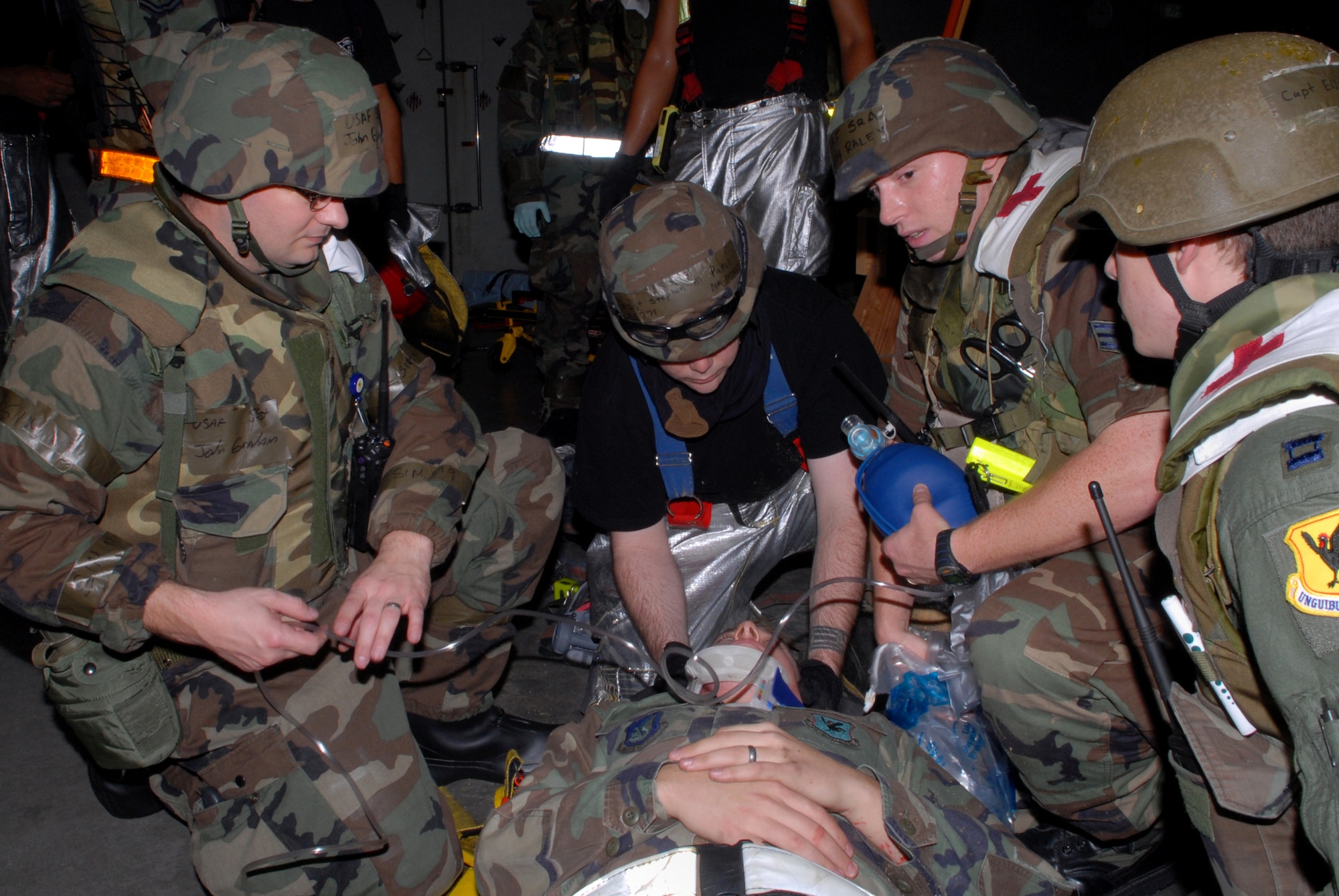 Airmen assigned to 18th Medical Operations Squadron and 18th Civil Engineer Group thoroughly assess Senior Airman James Wells, 718th Aircraft Maintenance Squadron, after pulling him from under debris during a structural and fire scenario in Bldg. 798, during Local Operational Readiness Exercise Beverly High 08-3 at Kadena Air Base, Japan, Jan. 9, 2007. The 18th Wing conducted the exercise from Jan. 7 to 11 to test the wing's ability to respond in contingency situations. 
(U.S. Air Force photo/Staff Sgt. Chrissy FitzGerald)
