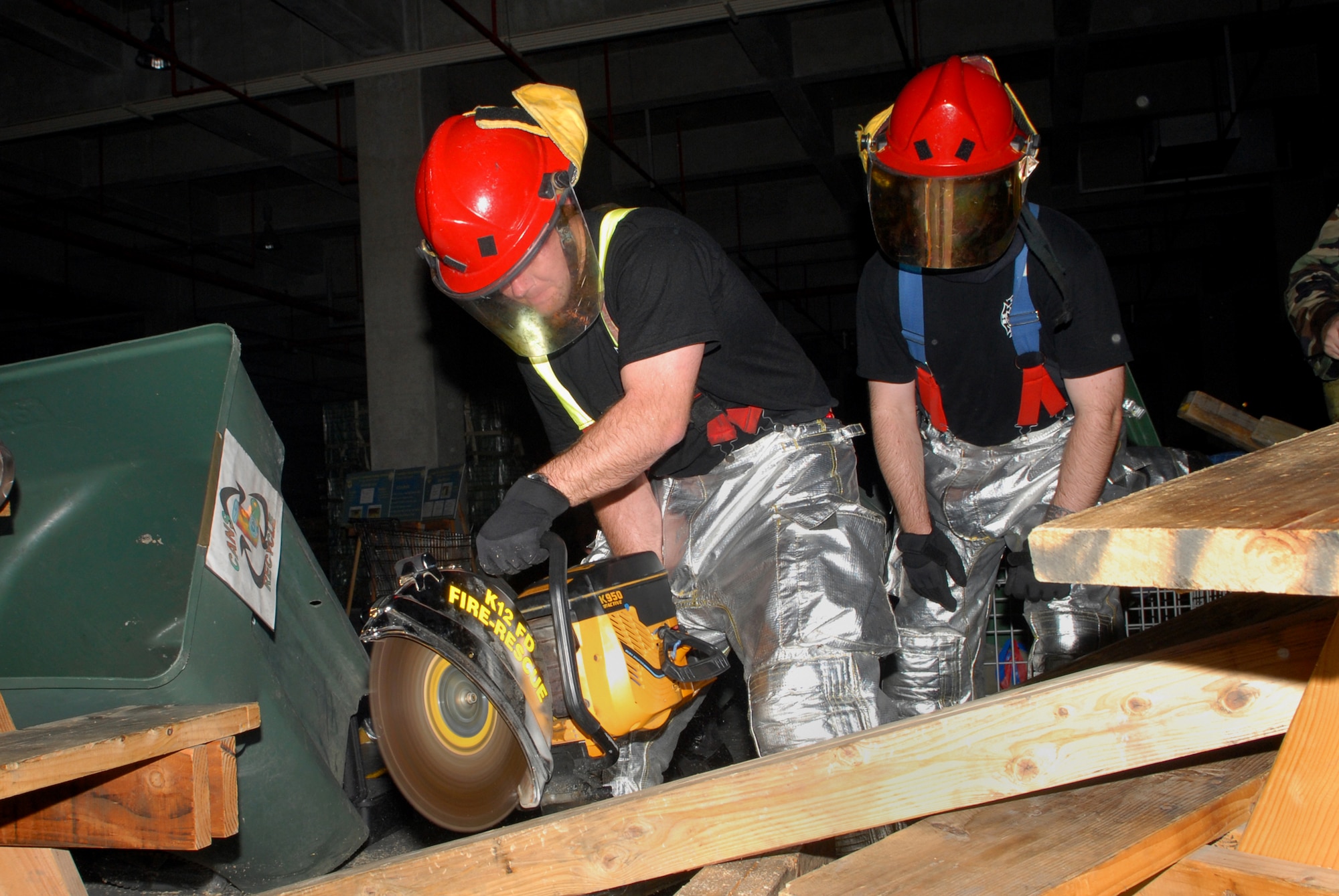 Two firefighters assigned to the 18th Civil Engineer Group, cut through debris to extricate a victim in a structural and fire scenario at Bldg. 798, during Local Operational Readiness Exercise Beverly High 08-3 at Kadena Air Base, Japan, Jan. 9, 2007. The 18th Wing conducted the exercise from Jan. 7 to 11 to test the wing's ability to respond in contingency situations. 
(U.S. Air Force photo/Staff Sgt. Chrissy FitzGerald)