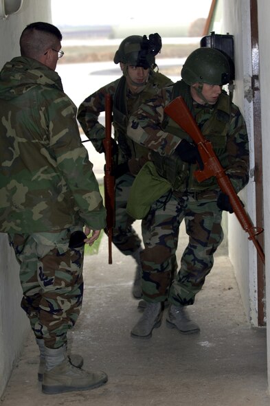 Airman 1st Class Adam Wilson, right front, and Airman 1st Class Alan Love, back right, 39th Security Forces Squadron, move into position as they train on clearing and inspecting buildings for foreign objects, Staff Sgt. Christopher Summers, left, 39 SFS trainer, observes how they perform, Jan. 7. All first term SFS Airmen go through a two week training course to prepare them for whatever comes their way.  (U.S. Air Force photo by Airman 1st Class Nathan Lipscomb)