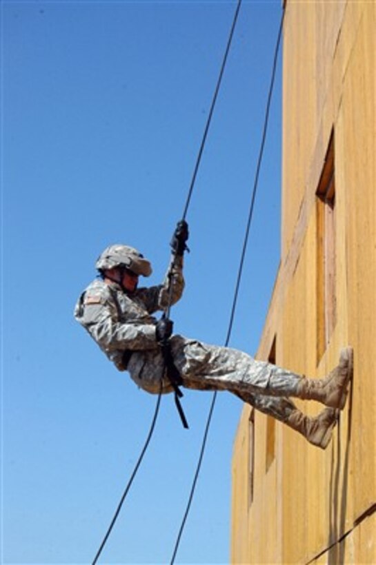 U.S. Army Pfc. Joshua L. Bettle locks out his rappelling equipment while rappelling down a tower at Camp Lemonier, Djibouti, on Jan. 4, 2008.  Bettle is attached to the Army's Delta Company, 1st Battalion, 3rd Infantry Regiment.  