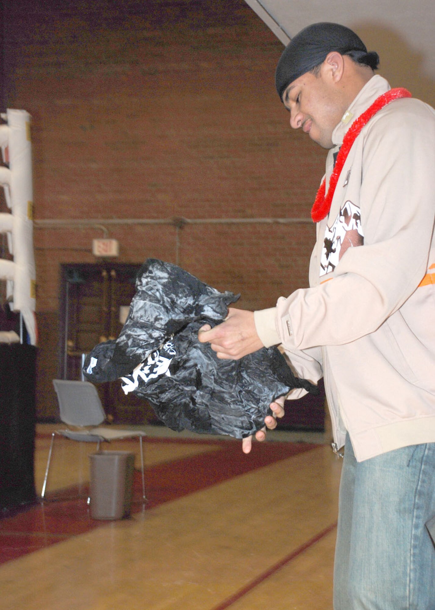 Airman 1st Class Kareem Pore, 90th Logistics Readiness Squadron, unfolds a frozen shirt for a contest at the community center. Participants of the Airman late nighter raced to pry open the shirt and be the first to do it.
