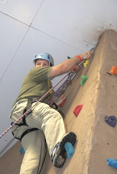 Senior Airman Mark Thieken, 90th Civil Engineer Squadron, climbs the rock wall at the community center in a timed event to reach an imprisoned dashboard hula-girl doll. Airman 1st Class Miguel Streety, 90th Medical Operations Squadron, and Airman Michael Taylor, 790th Missile Security Forces Squadron, tied for the win with 17 seconds.